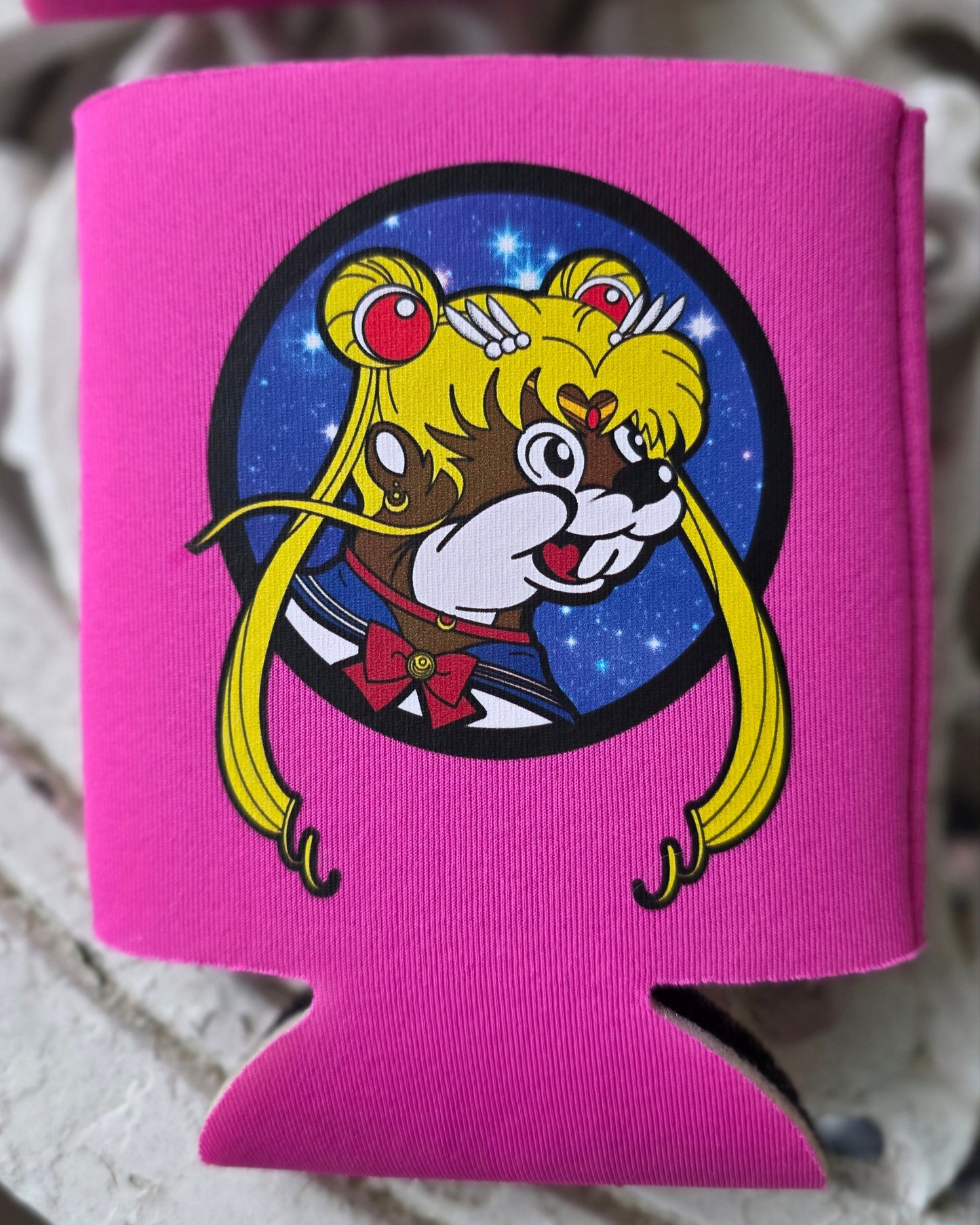Pink can cooler with cartoon character design on a textured surface