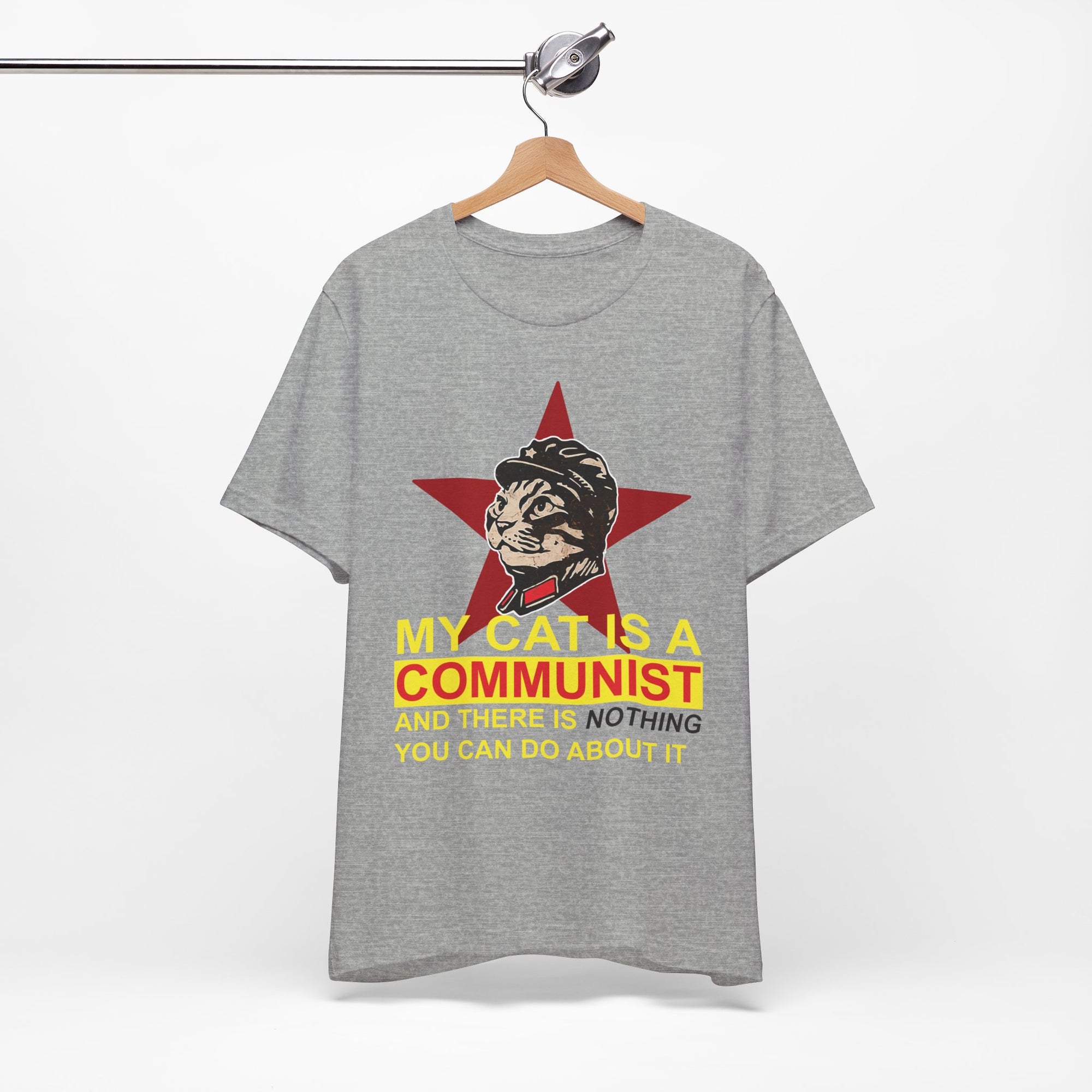 Gray t-shirt with a graphic of a cat in a communist uniform and text on a hanger against a white background