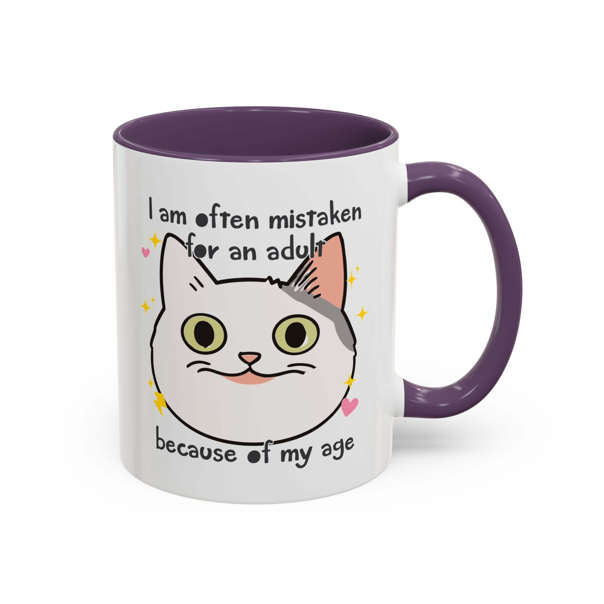 White ceramic mug with purple handle and interior featuring a cute wide-eyed cat face, hearts, sparkles, and the phrase “I am often mistaken for an adult because of my age.”
