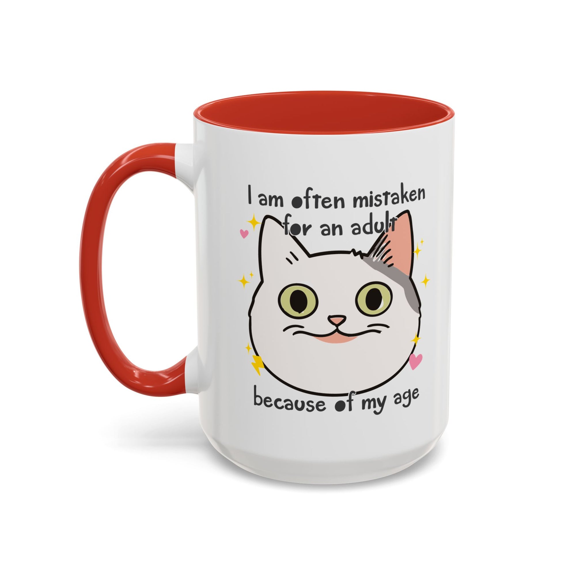 White ceramic mug with red handle and interior featuring a cute wide-eyed cat face, hearts, sparkles, and the phrase “I am often mistaken for an adult because of my age.”
