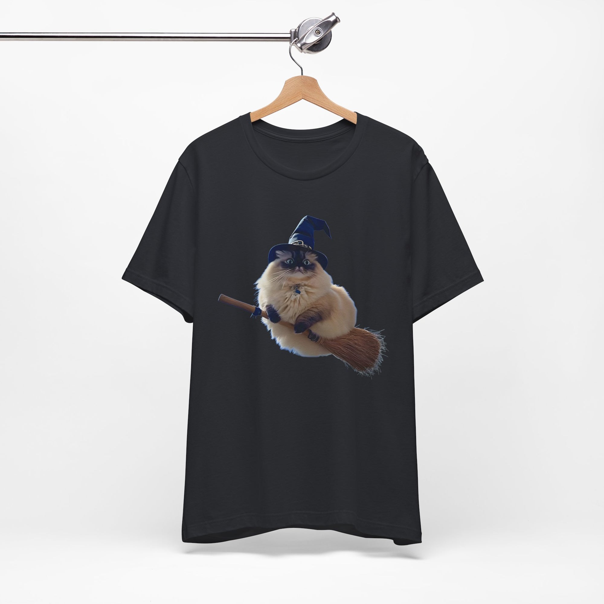 Black t-shirt with a graphic of a cat in a wizard hat on a broomstick, hanging on a wooden hanger against a white background.