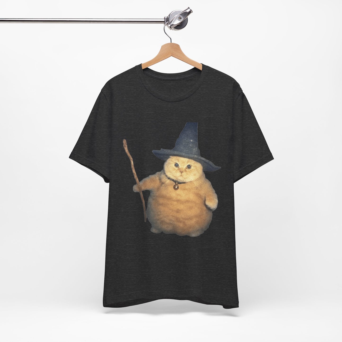 Black t-shirt with a cat wearing a witch hat and broomstick on a hanger against a white background