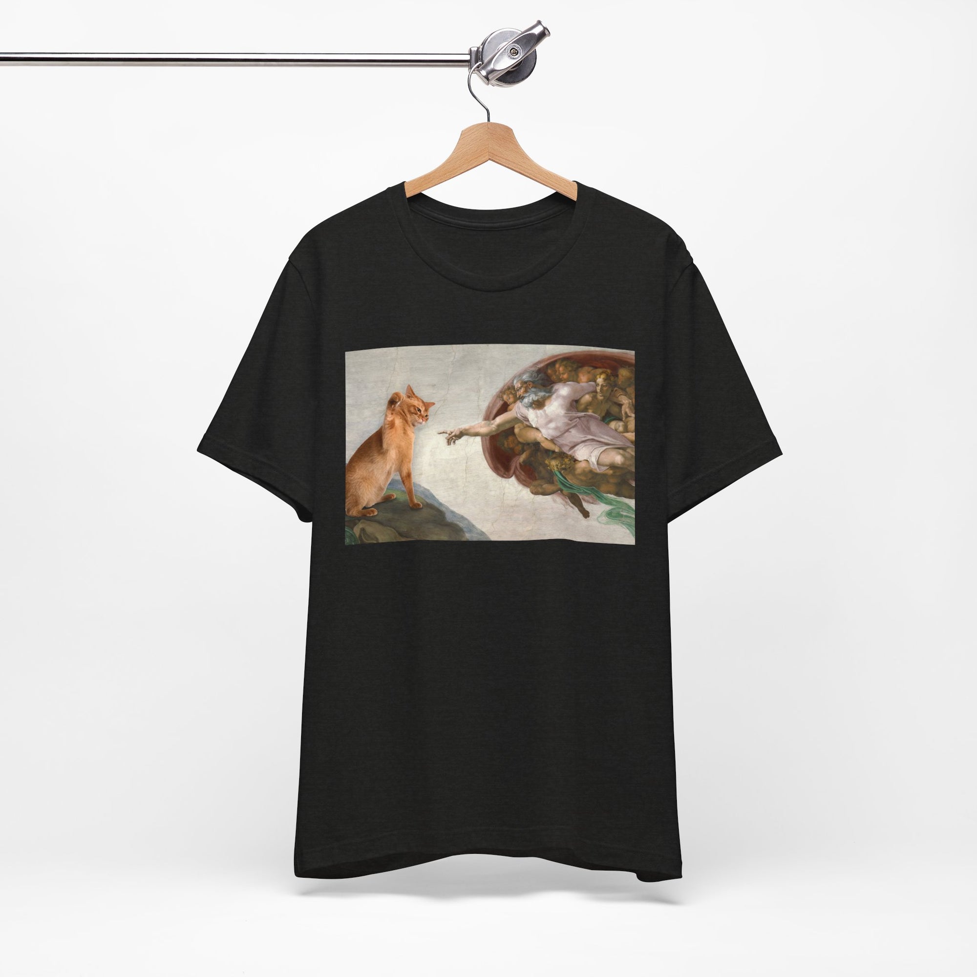 Black t-shirt with a graphic design of a cat and god on a hanger against a white background