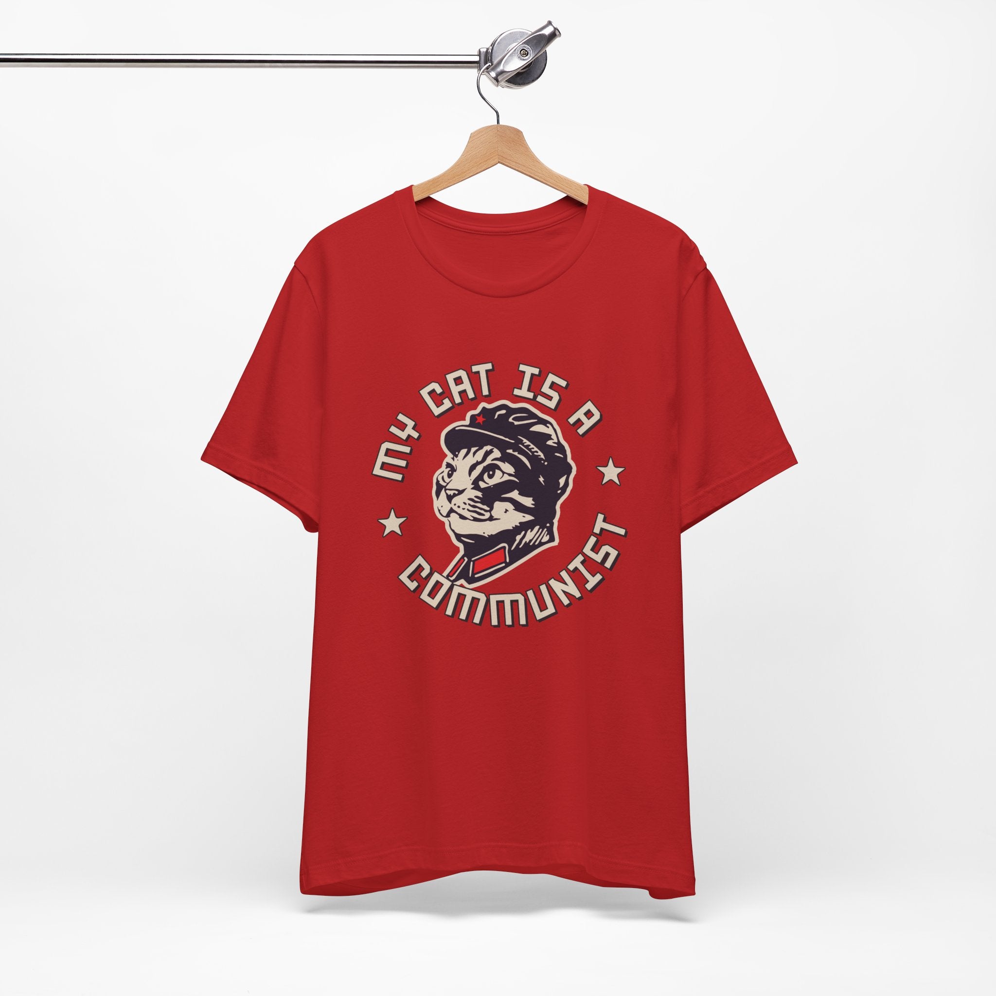 Red t-shirt with a graphic design of a cat and text on a hanger against a white background