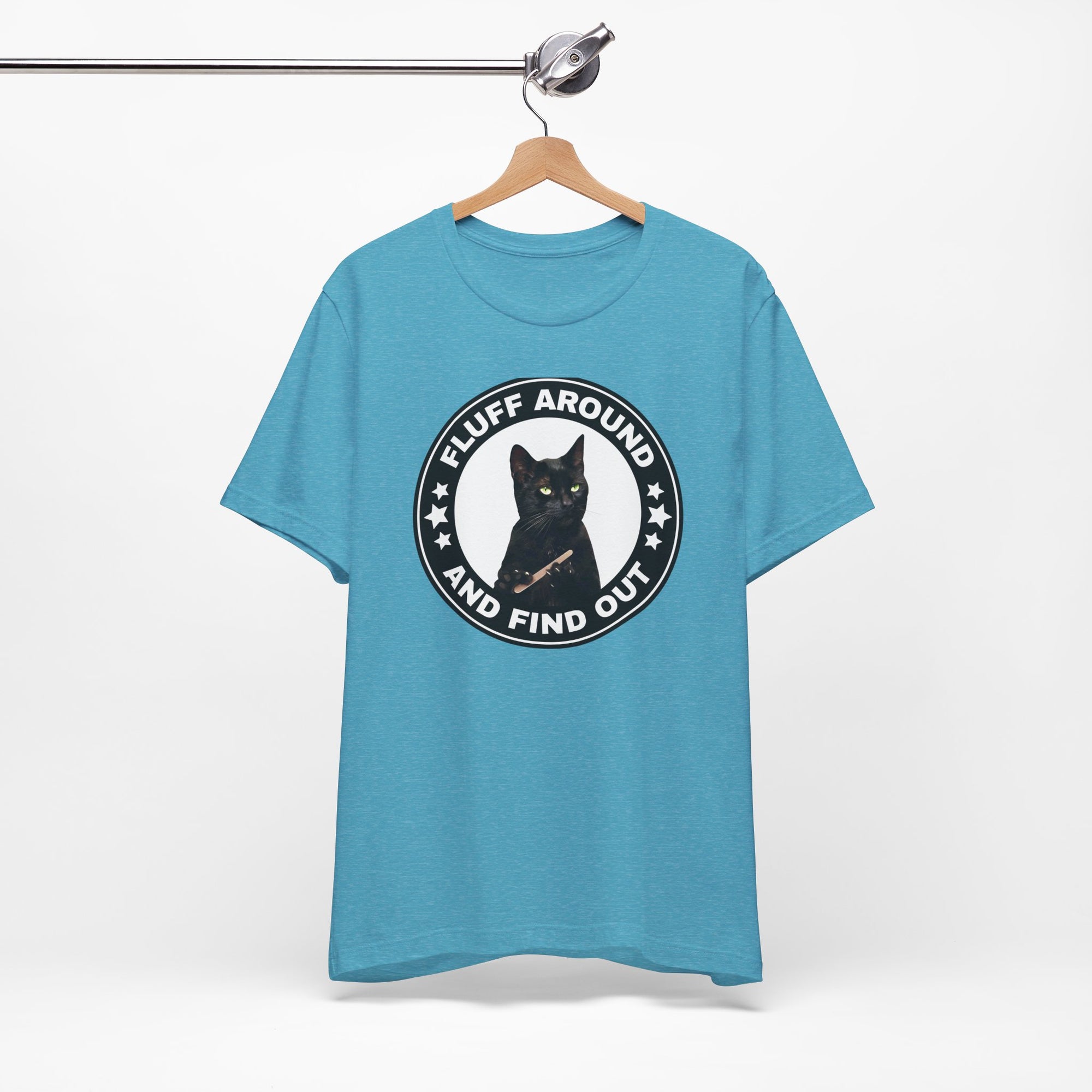 t-shirt featuring a circular badge design with a black cat and the phrase “Fluff Around and Find Out.”