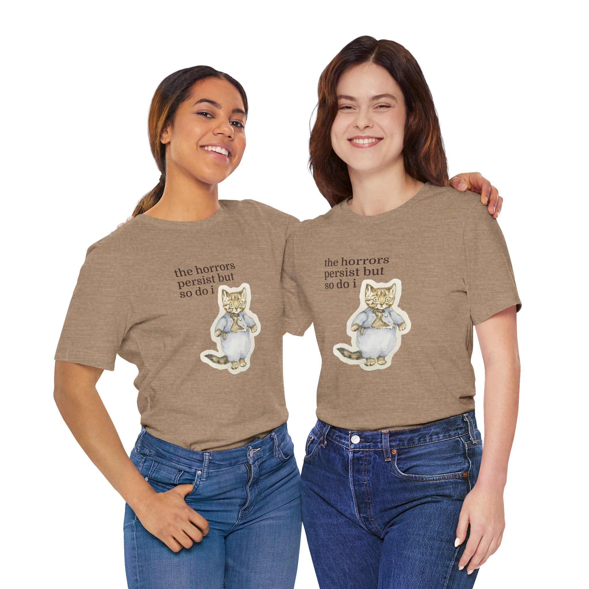 Two people wearing matching brown t-shirt featuring a vintage-style illustrated cat in blue clothing with the phrase “the horrors persist but so do i.”