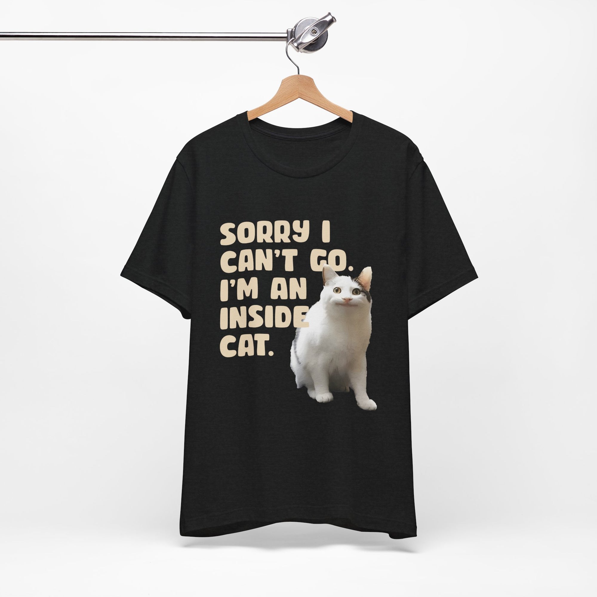 Black t-shirt with a white cat graphic and text on a hanger against a white background