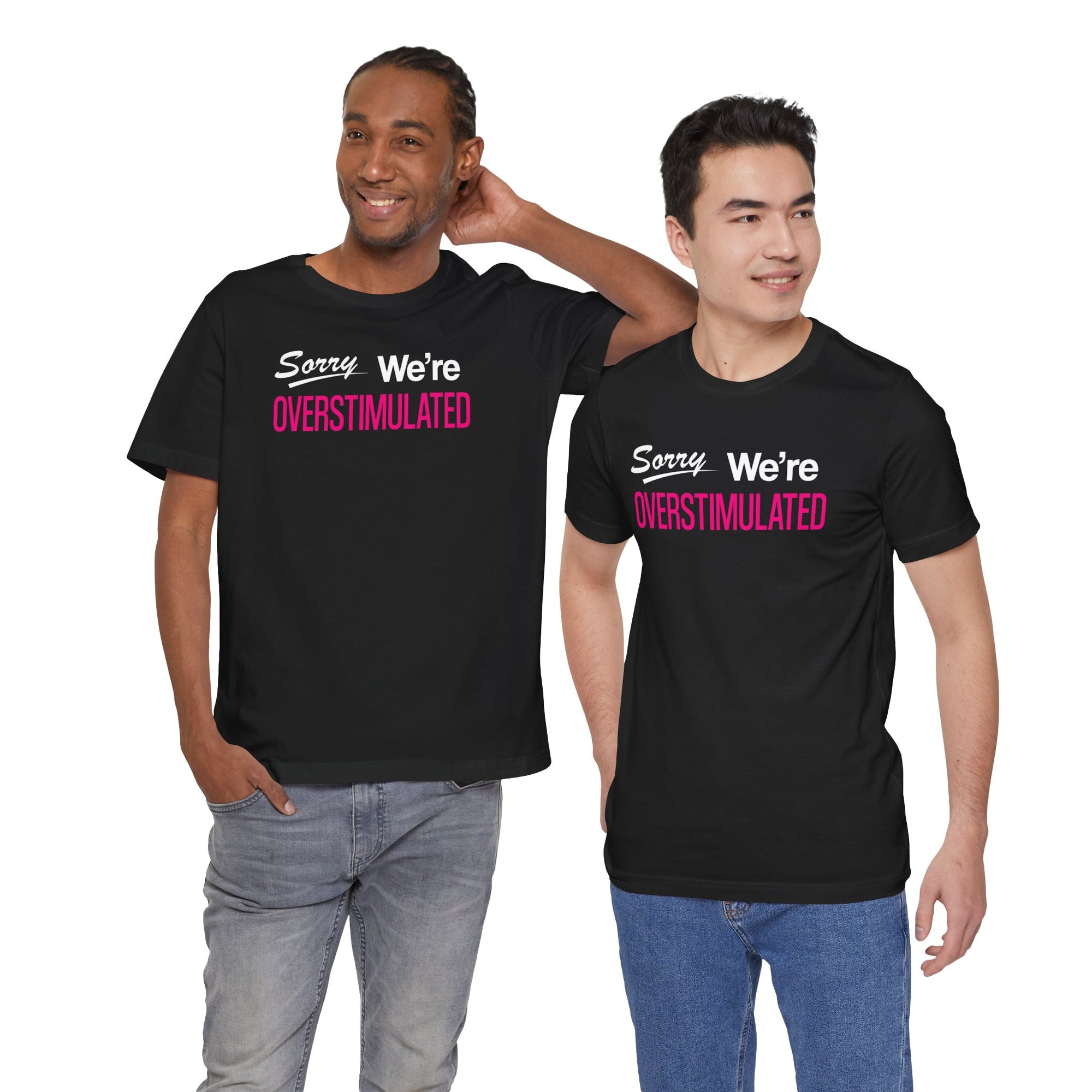Two men wearing black t-shirt featuring the phrase “Sorry We’re Overstimulated” in white and hot pink text.
