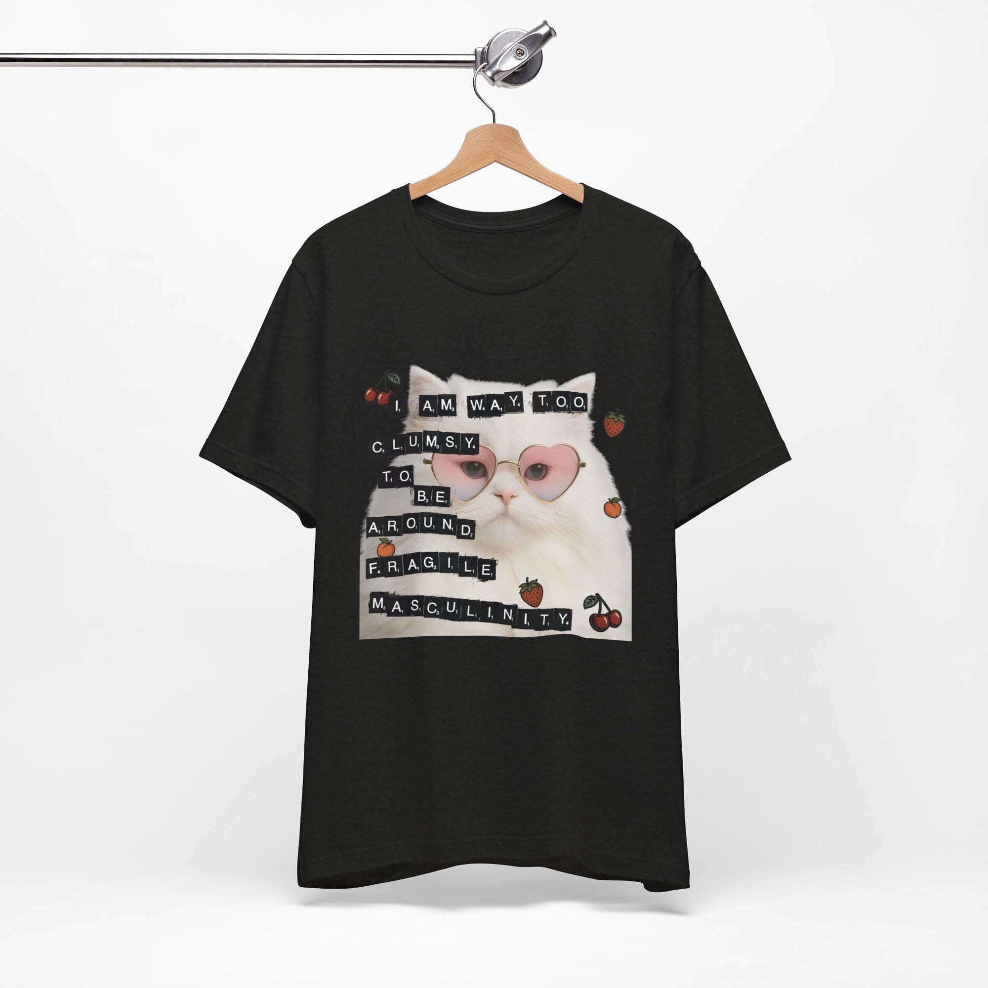 Black t-shirt featuring a fluffy white cat in pink heart-shaped sunglasses with ransom-note style text that says “I am way too clumsy to be around fragile masculinity.”