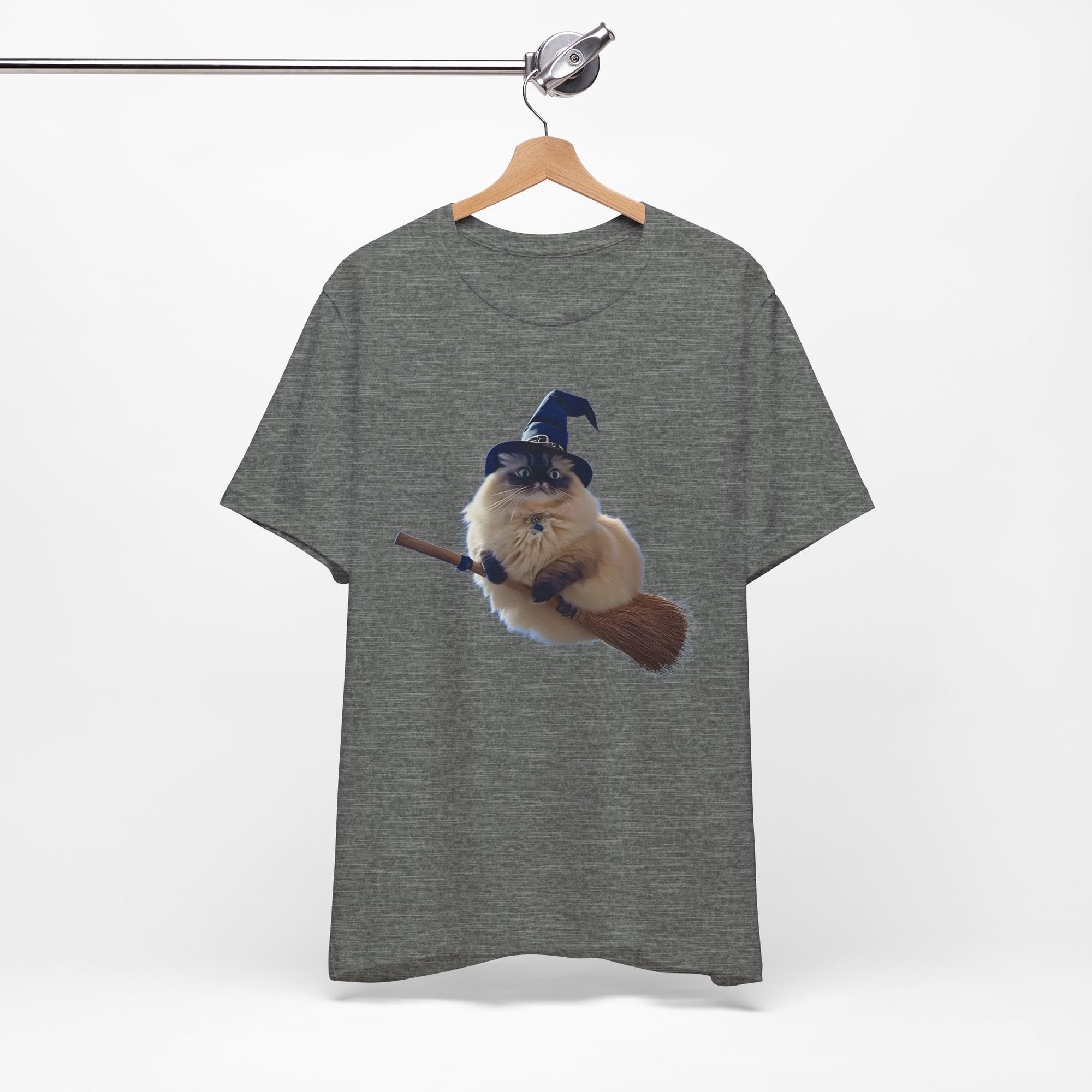 Gray t-shirt with a graphic of a cat in a witch hat and broomstick on a hanger against a white background.