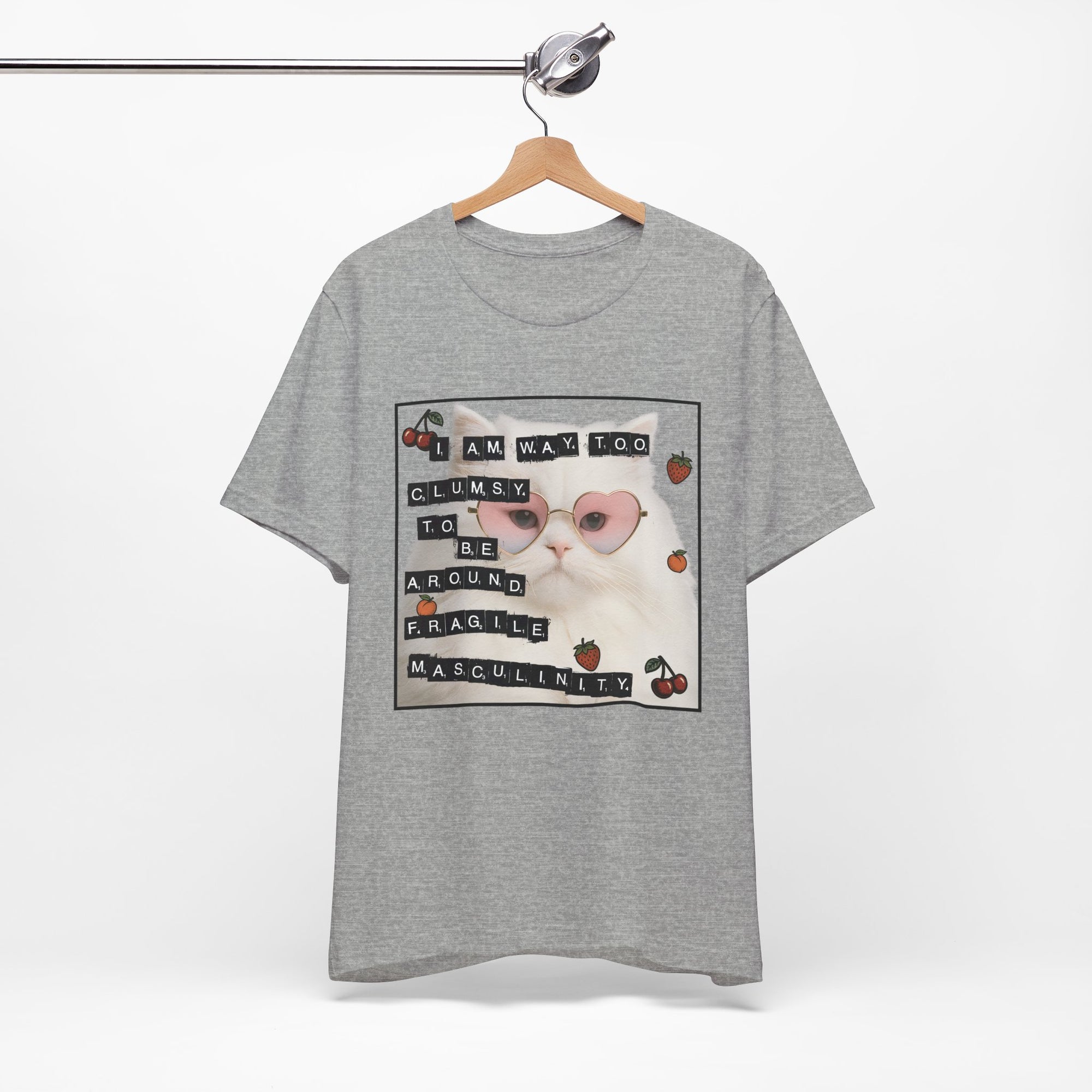 Gray t-shirt featuring a fluffy white cat in pink heart-shaped sunglasses with ransom-note style text that says “I am way too clumsy to be around fragile masculinity.”