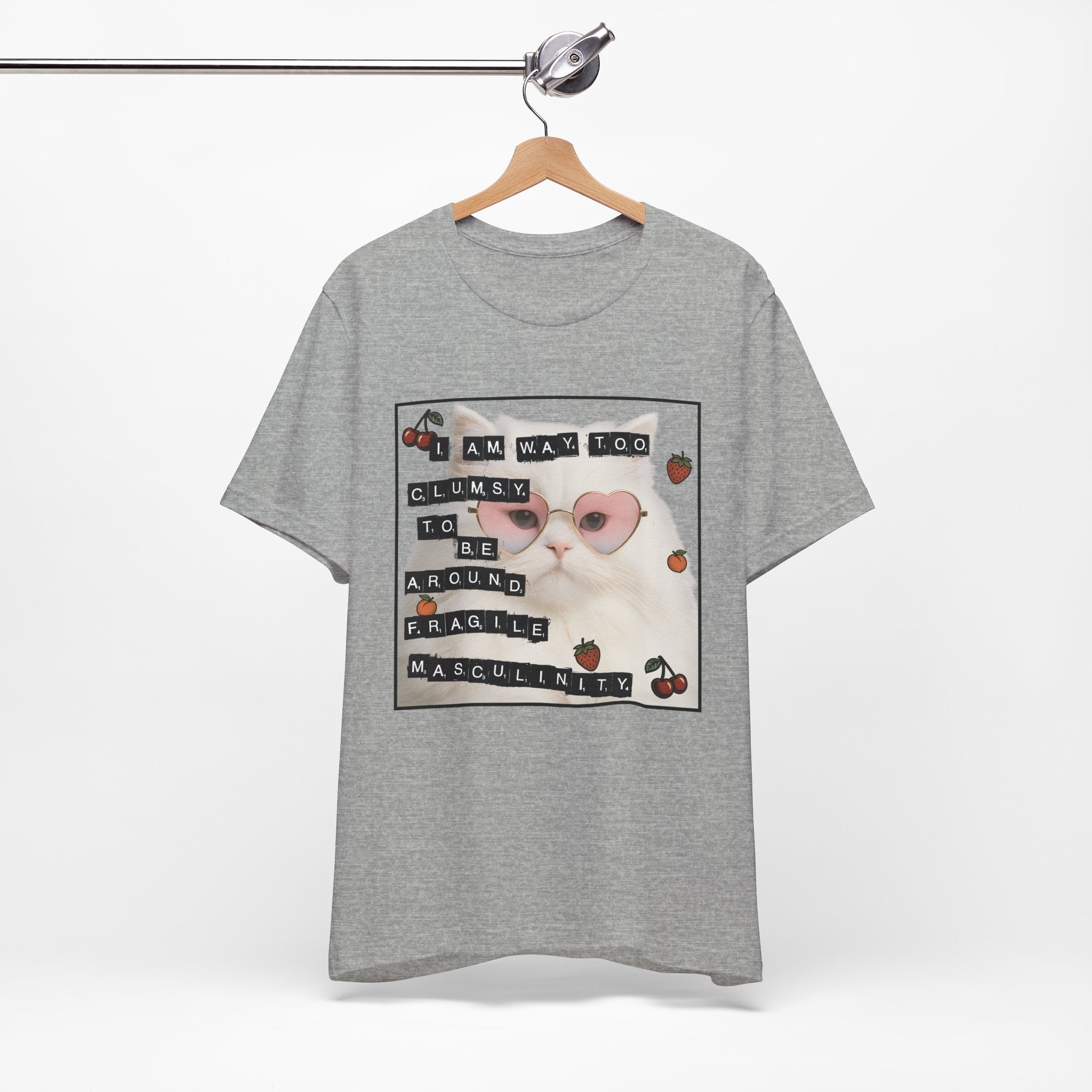 Gray t-shirt featuring a fluffy white cat in pink heart-shaped sunglasses with ransom-note style text that says “I am way too clumsy to be around fragile masculinity.”