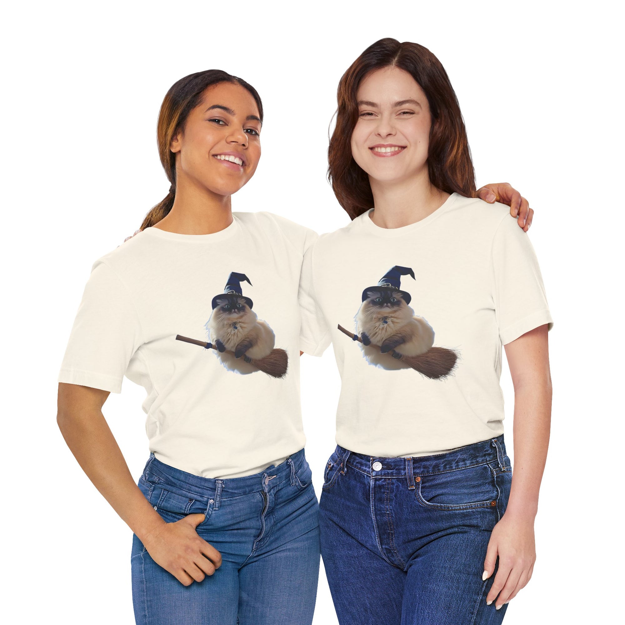 Two women wearing matching cream t-shirts with a graphic of a cat in a witch hat and broom.
