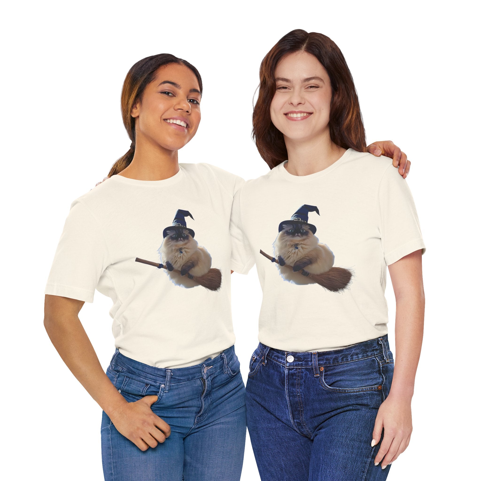 Two women wearing matching cream t-shirts with a graphic of a cat in a witch hat and broom.