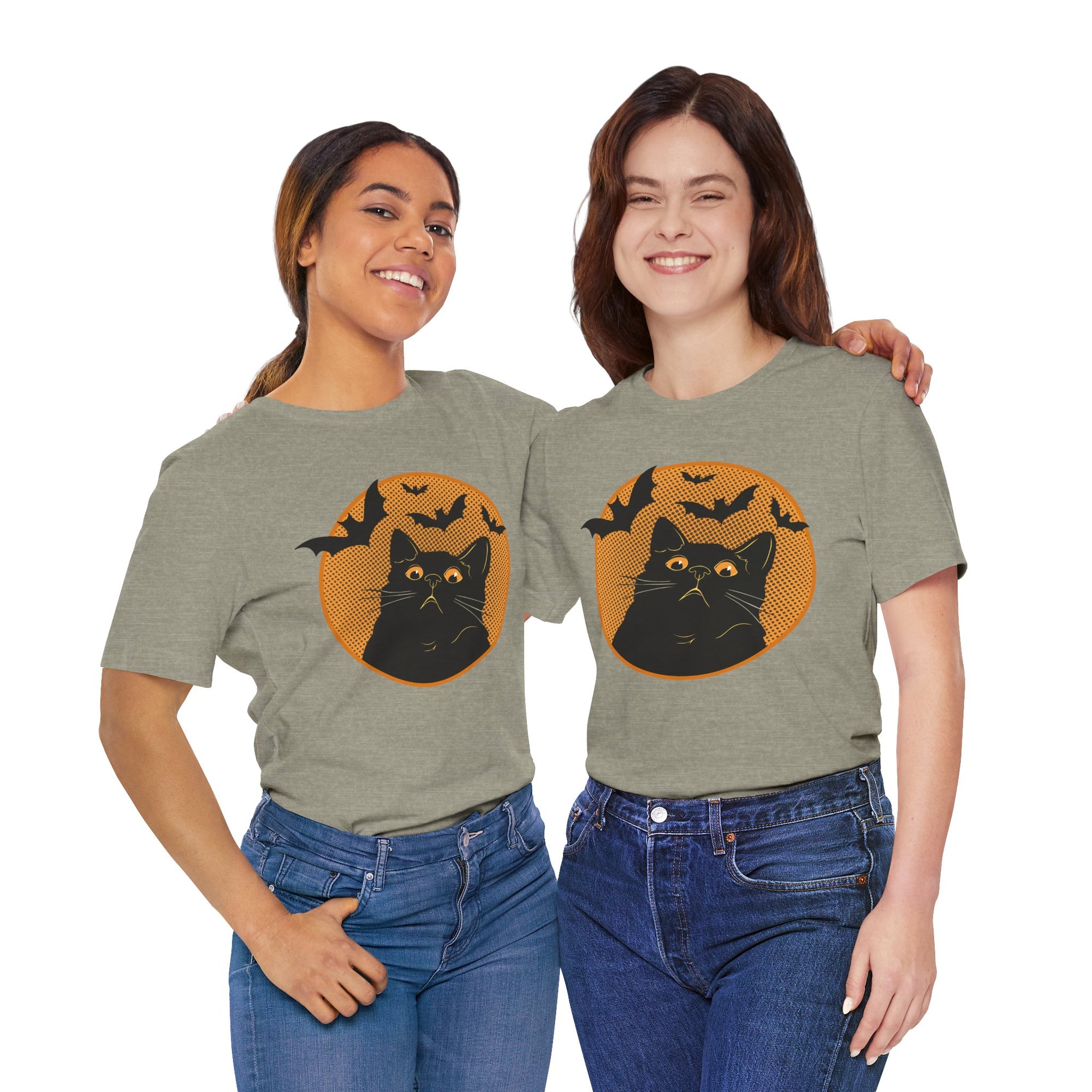 Two women wearing green t-shirts with a black cat and bat design on a white background