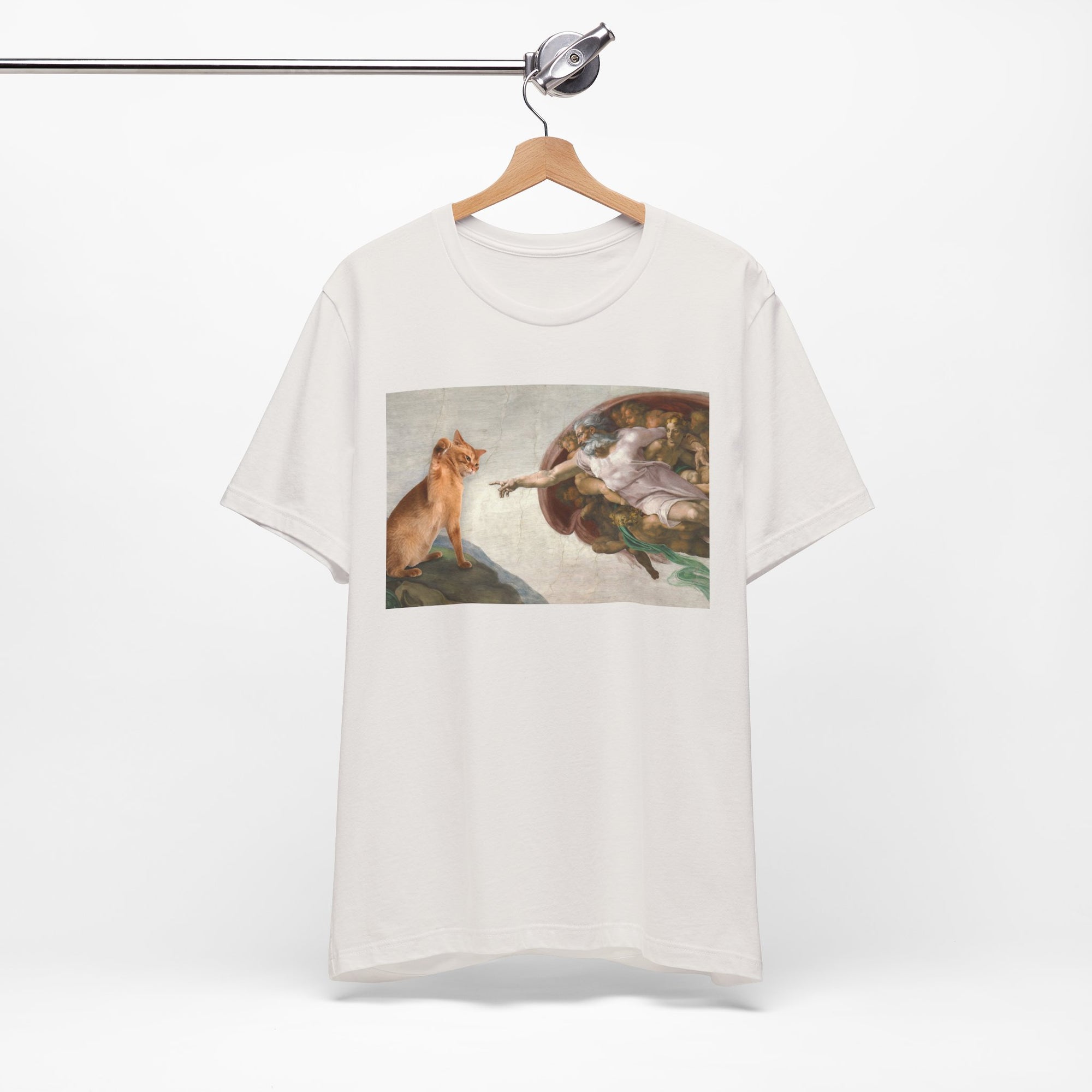 White t-shirt with a graphic design of a cat and god on a hanger against a white background