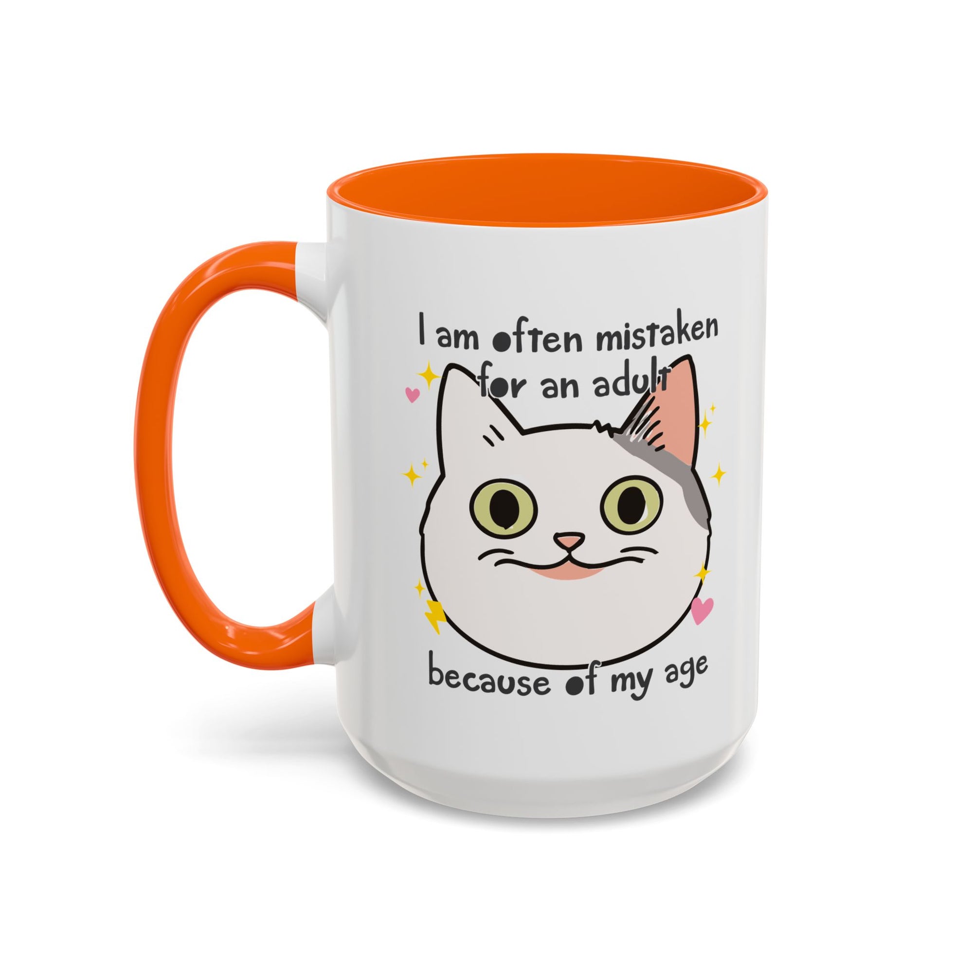 White ceramic mug with orange handle and interior featuring a cute wide-eyed cat face, hearts, sparkles, and the phrase “I am often mistaken for an adult because of my age.”
