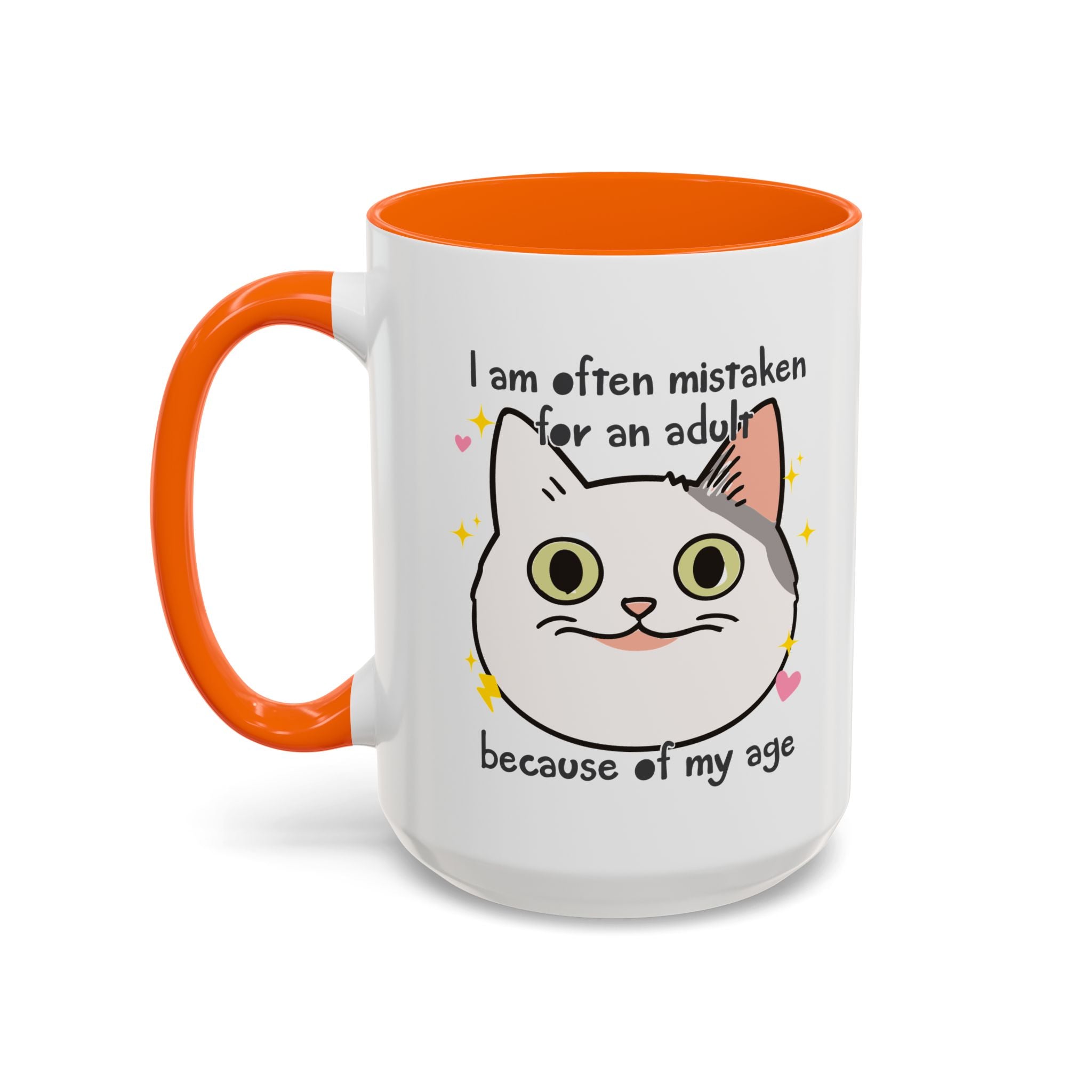 White ceramic mug with orange handle and interior featuring a cute wide-eyed cat face, hearts, sparkles, and the phrase “I am often mistaken for an adult because of my age.”

