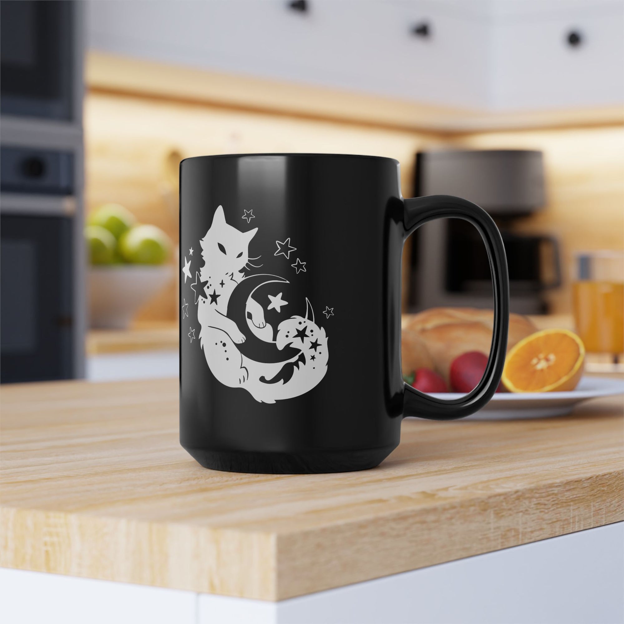 Black mug with a white cat and moon design on a kitchen counter.