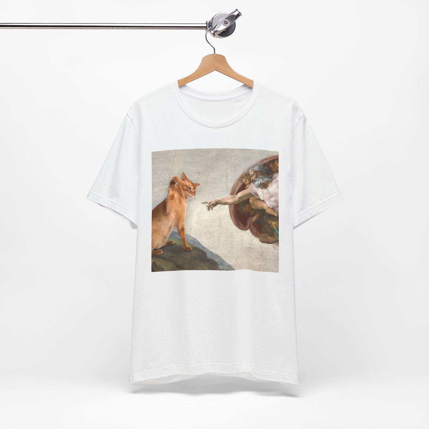 White t-shirt with a graphic design of a cat and angel on a hanger against a white background