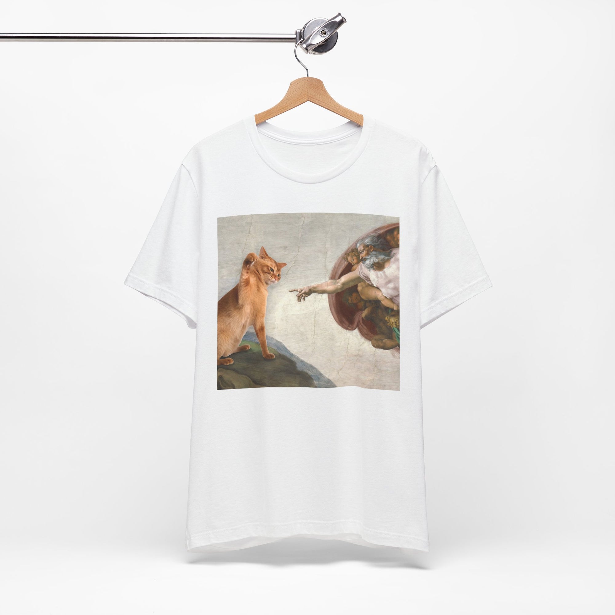 White t-shirt with a graphic design of a cat and angel on a hanger against a white background