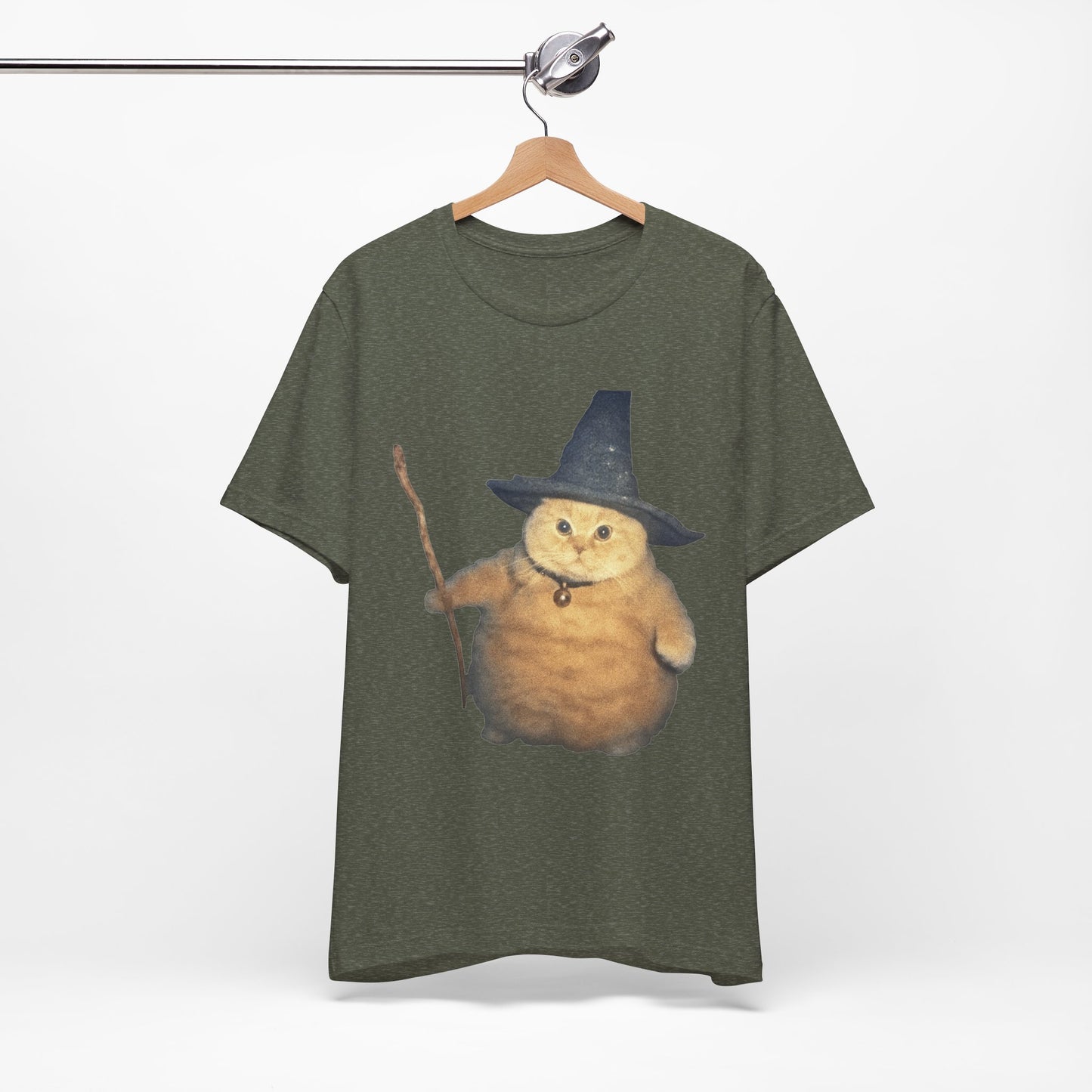 Green t-shirt with a cat wearing a wizard hat and holding a wand on a hanger against a white background.