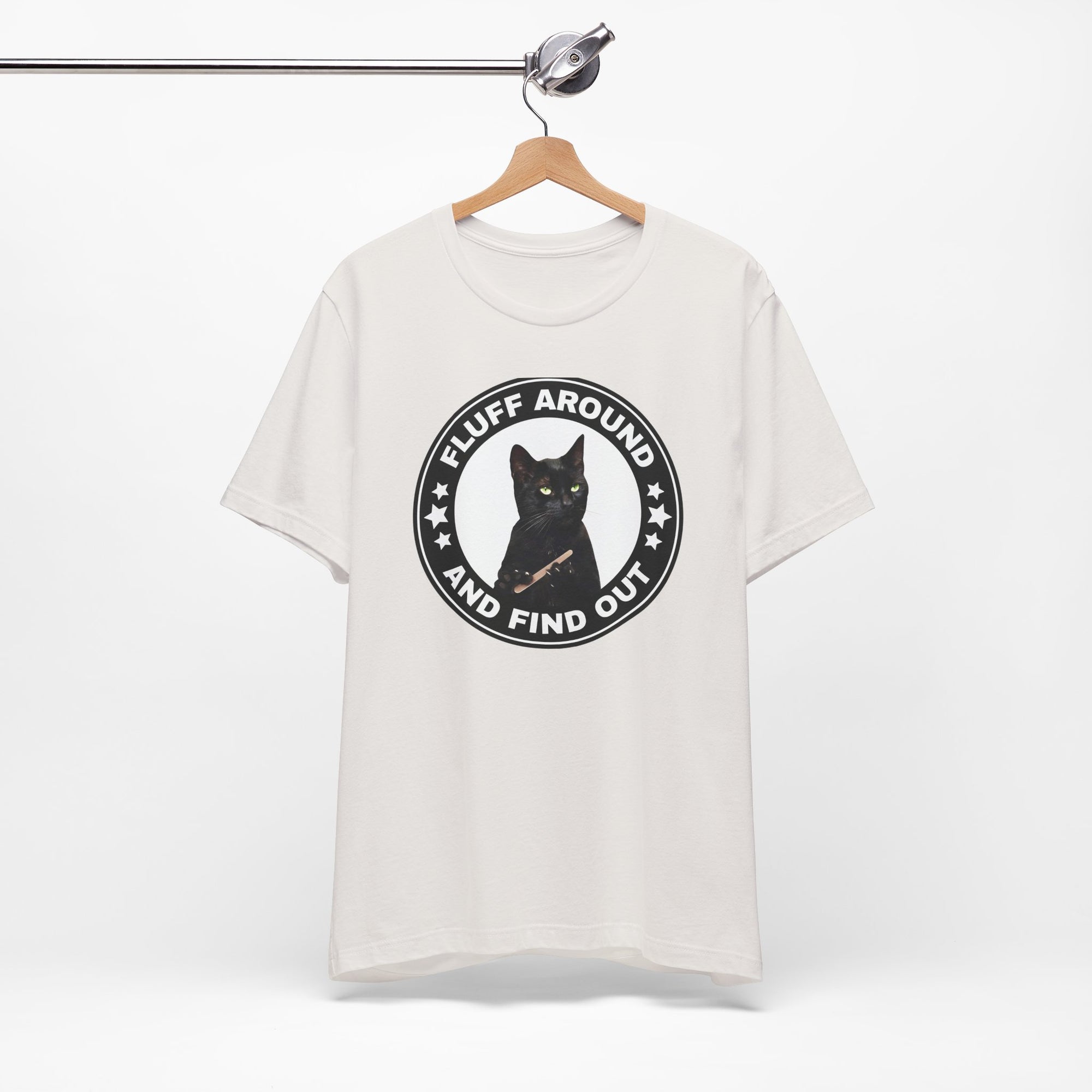 white t-shirt featuring a circular badge design with a black cat and the phrase “Fluff Around and Find Out.”
