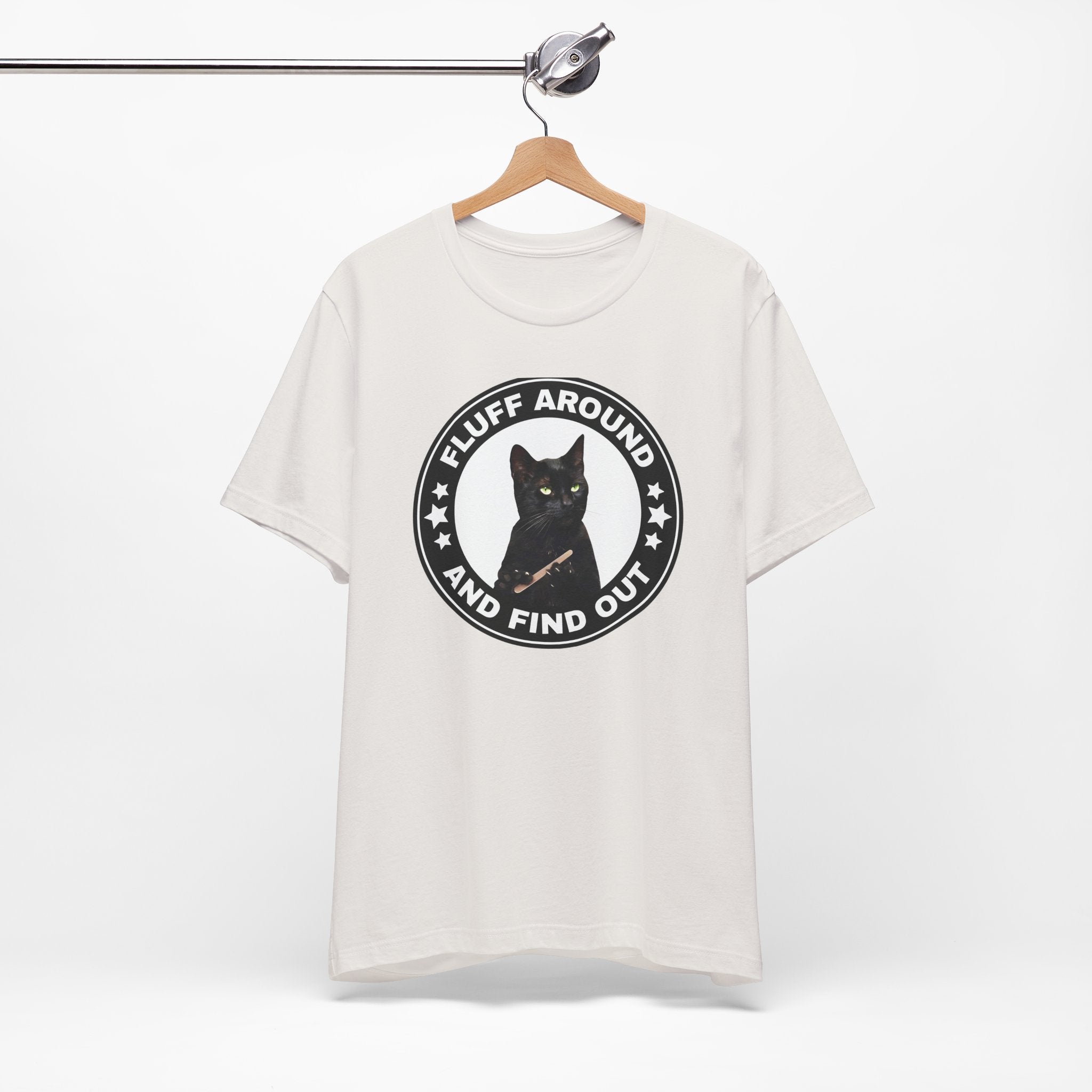 white t-shirt featuring a circular badge design with a black cat and the phrase “Fluff Around and Find Out.”
