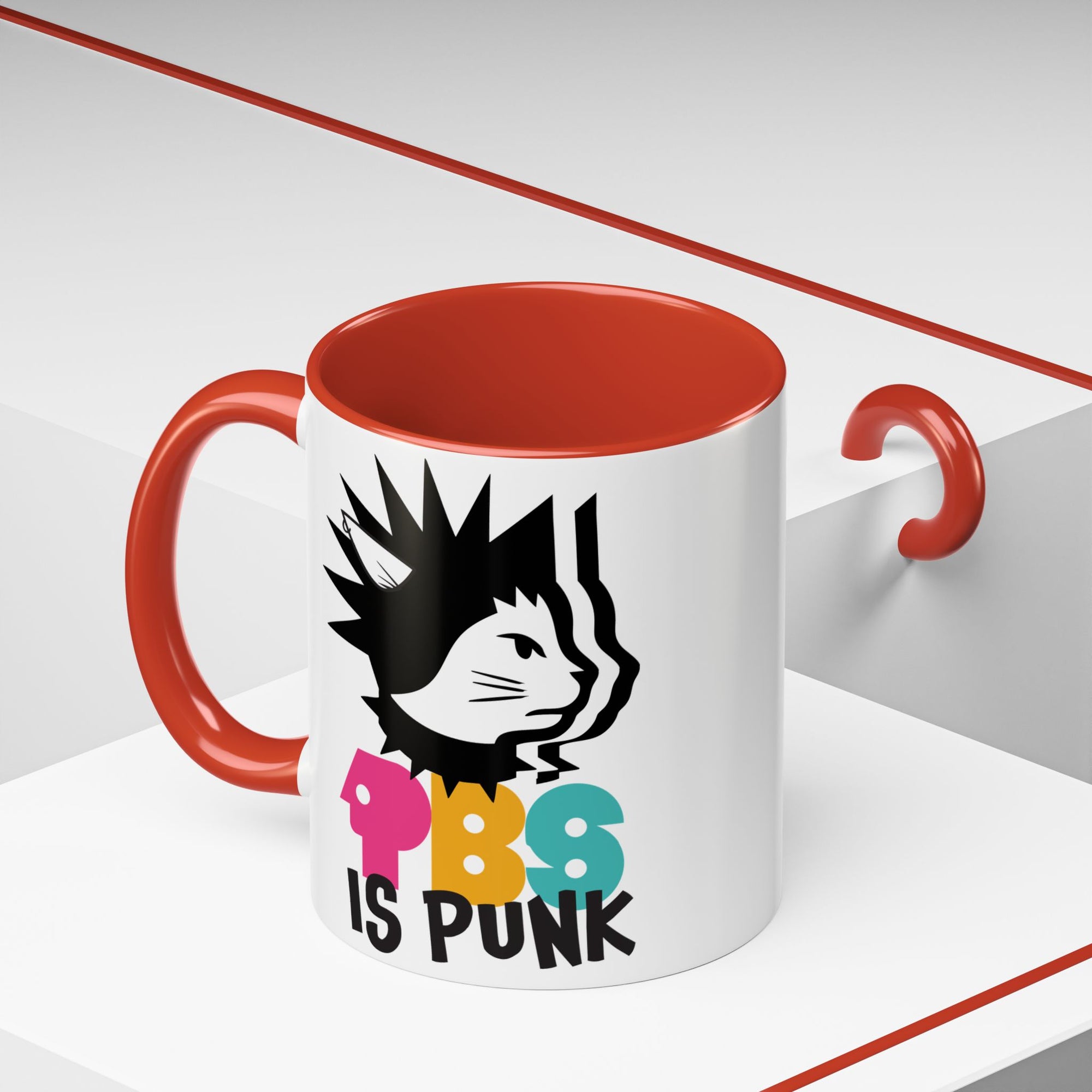 Mug with red interior and handle, featuring a graphic of a cat and colorful text on a white background.