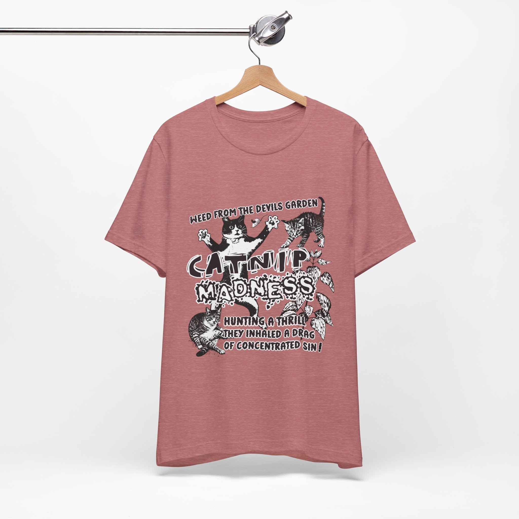Pink t-shirt with graphic design and text on a hanger against a white background
