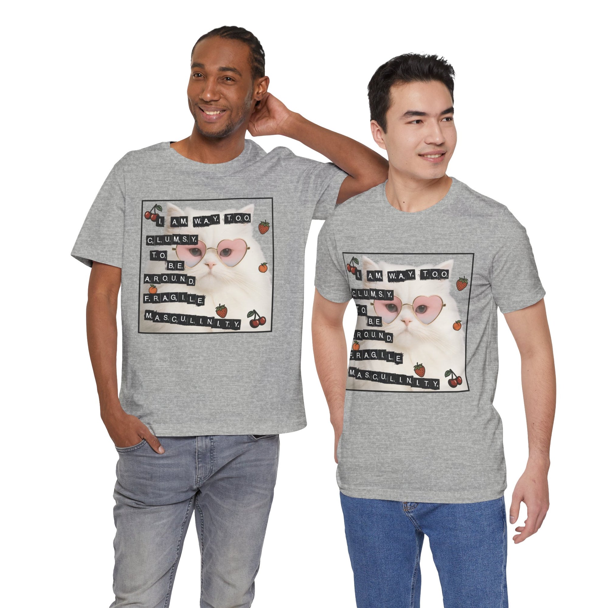 Two men wearing gray t-shirt featuring a fluffy white cat in pink heart-shaped sunglasses with ransom-note style text that says “I am way too clumsy to be around fragile masculinity.”