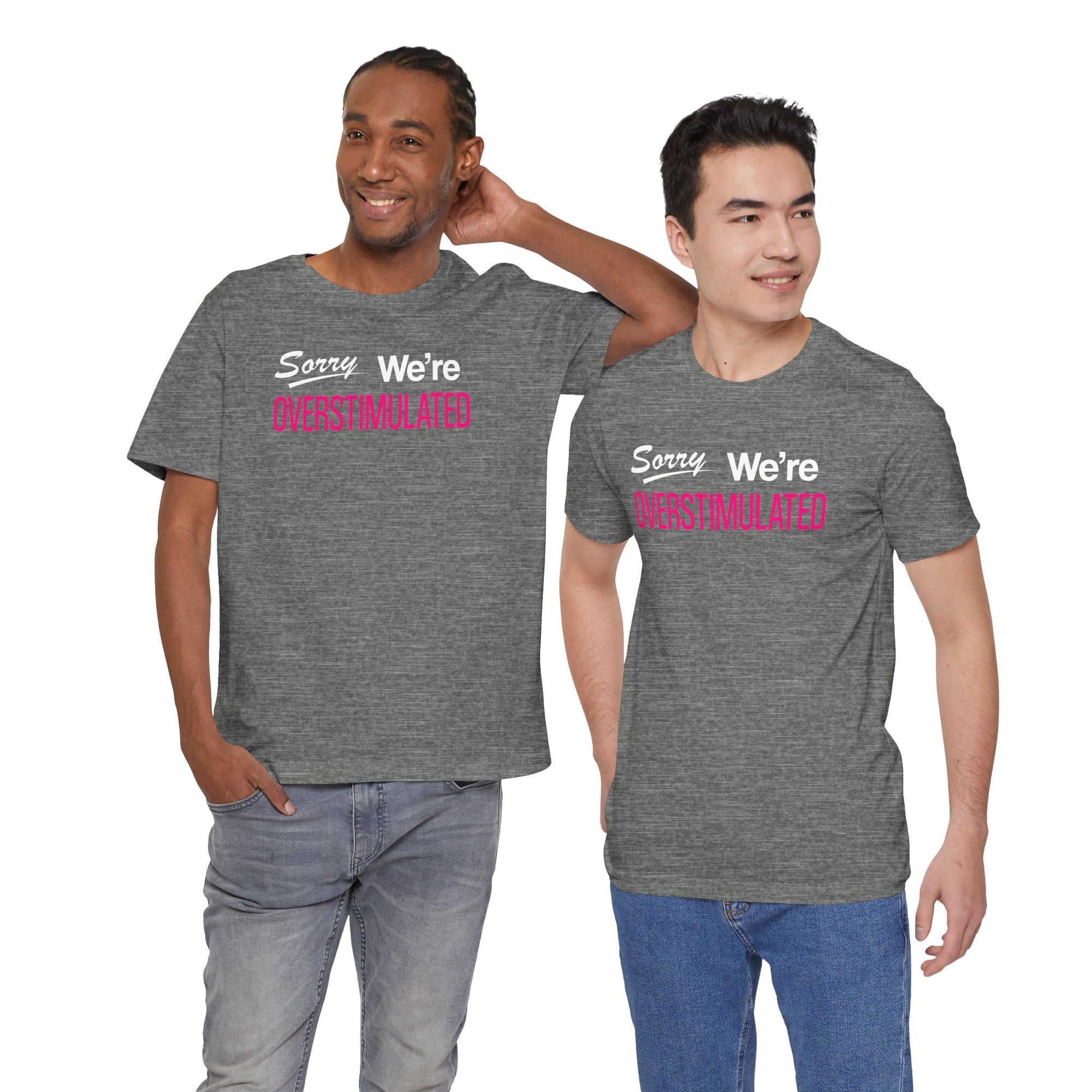 Two men wearing gray t-shirt featuring the phrase “Sorry We’re Overstimulated” in white and hot pink text.
