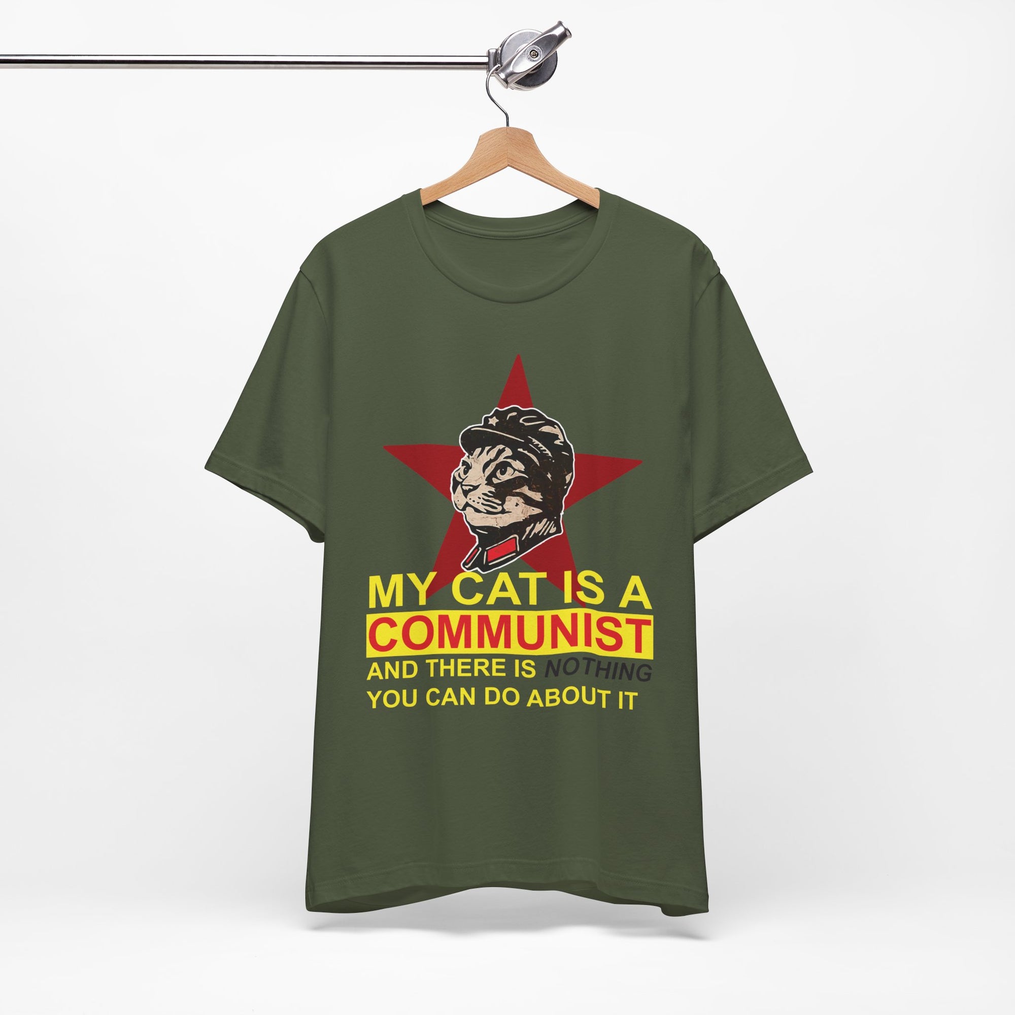 Green t-shirt with a graphic of a cat in a communist uniform and text on a hanger against a white background