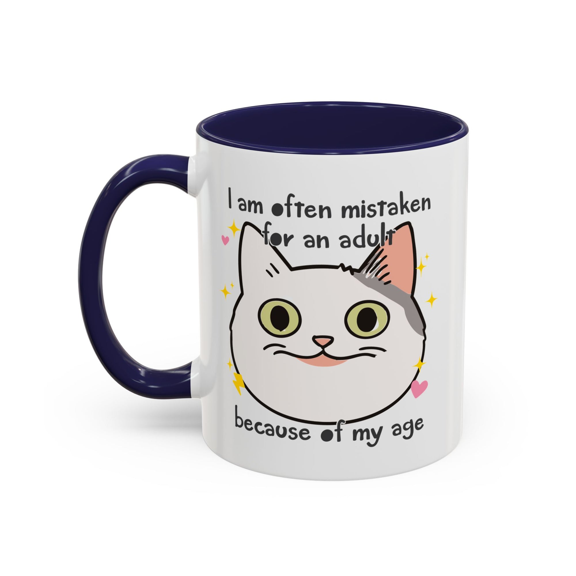 White ceramic mug with purple handle and interior featuring a cute wide-eyed cat face, hearts, sparkles, and the phrase “I am often mistaken for an adult because of my age.”
