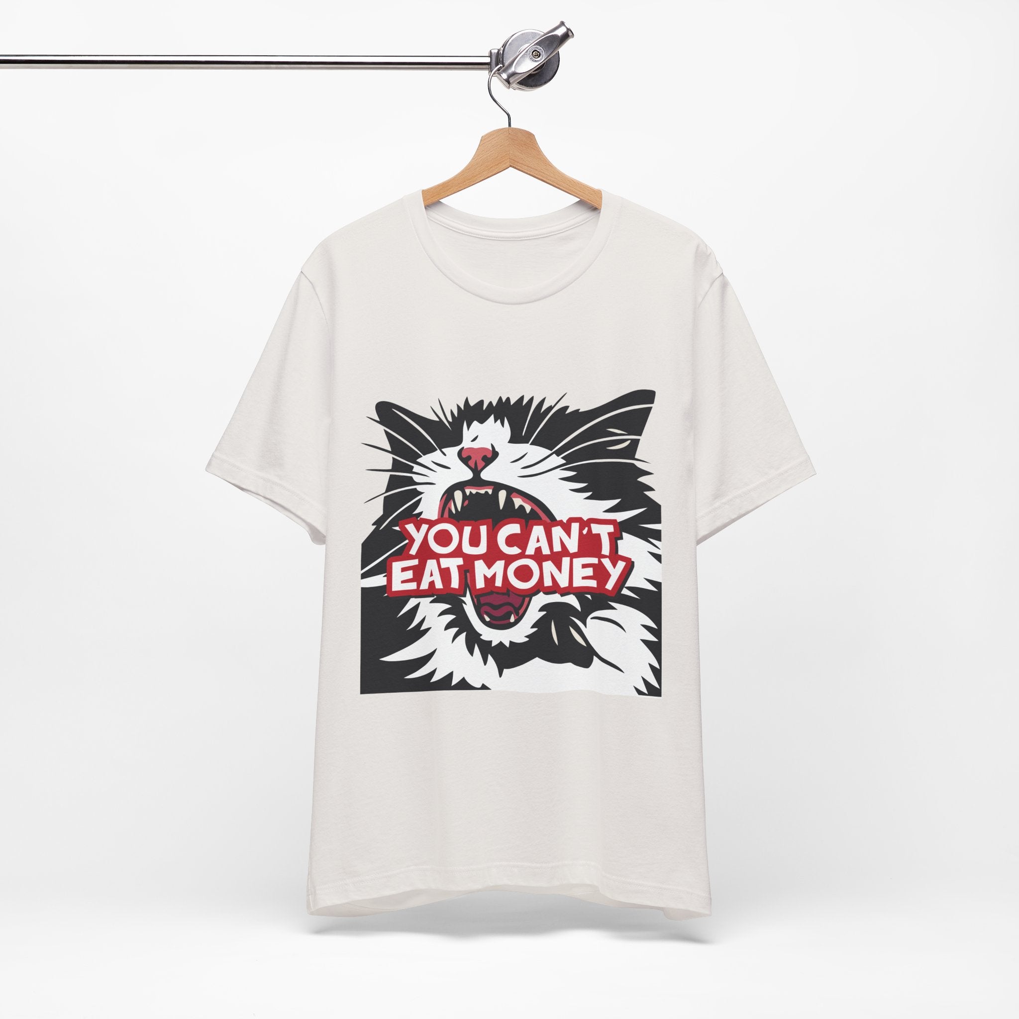 Off white t-shirt featuring a bold black, white, and red angry cat graphic with the phrase “You Can’t Eat Money.”

