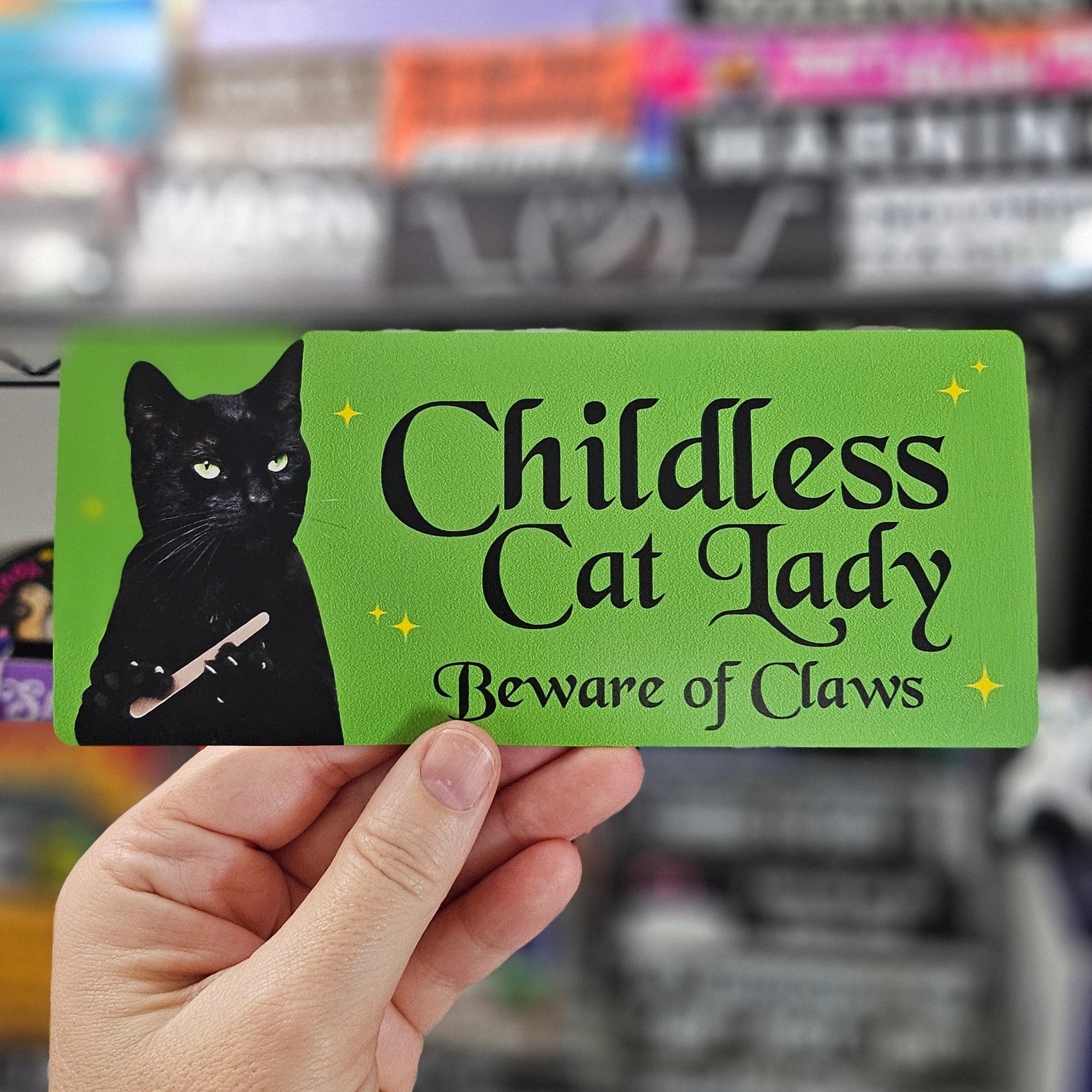 Rectangular sticker with a black cat holding a nail file beside the words “Childless Cat Lady” and “Beware of Claws,” shown in white and holographic versions.