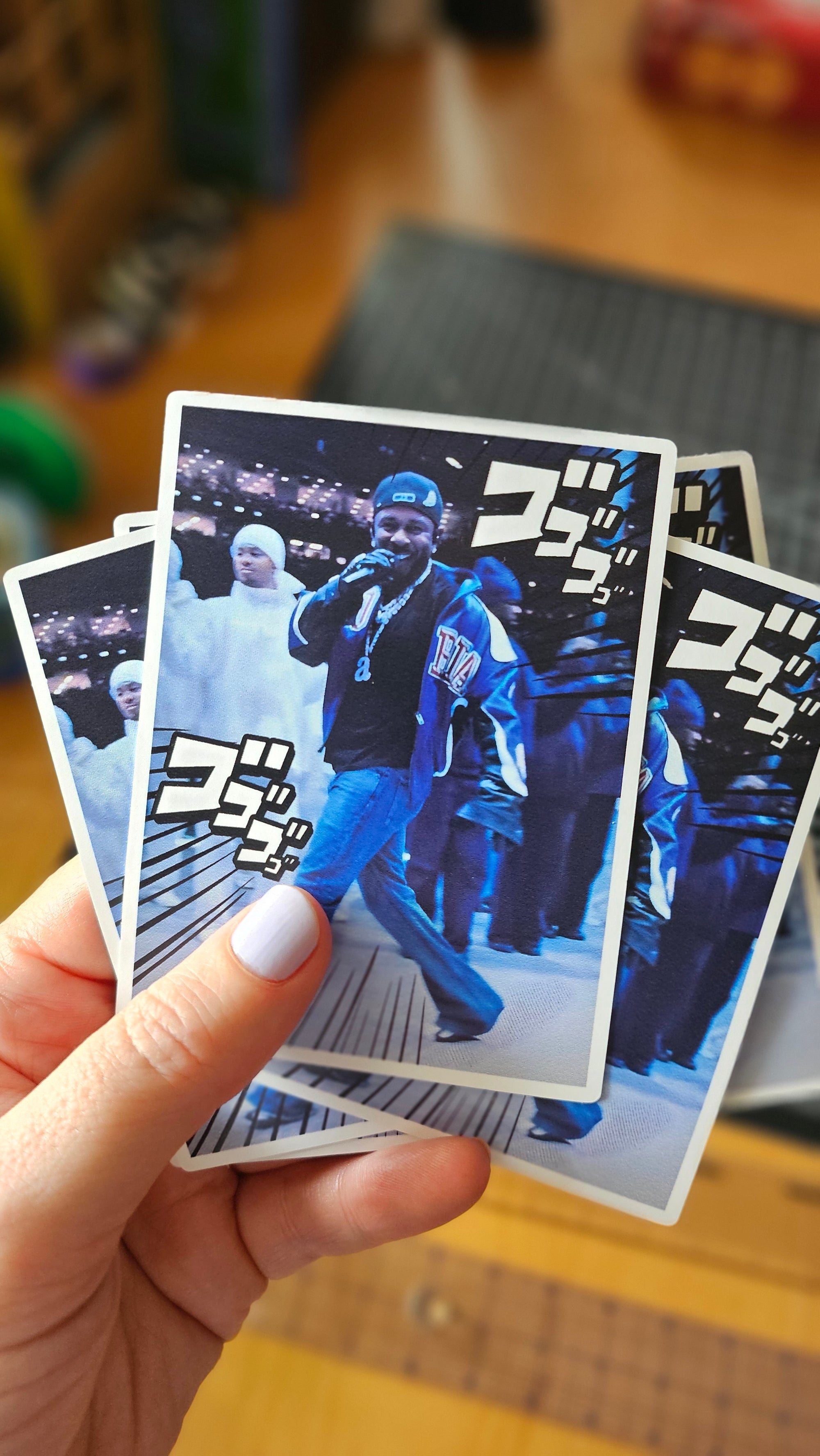 Rectangular photo-style sticker featuring a rapper walking through a blue-toned scene with bold manga-style action text accents.

