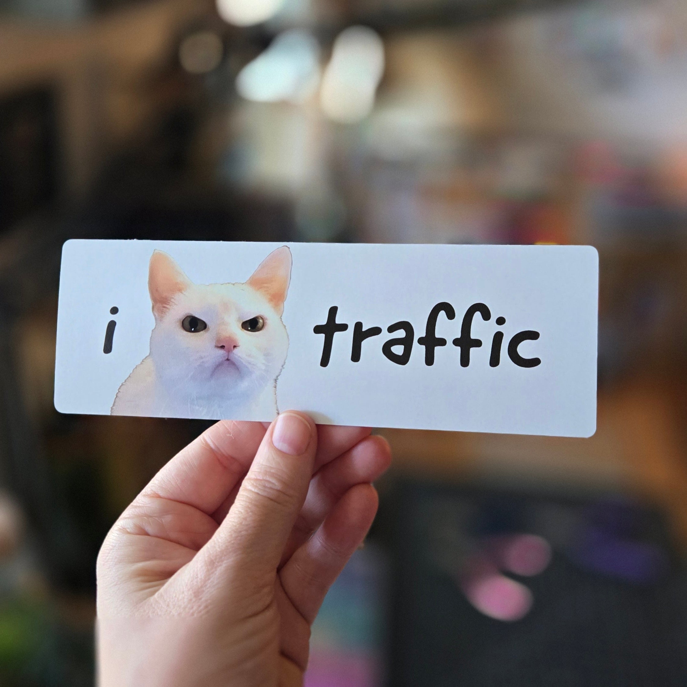 white rectangular sticker featuring a cat with 'i 😾 traffic' text on a white background