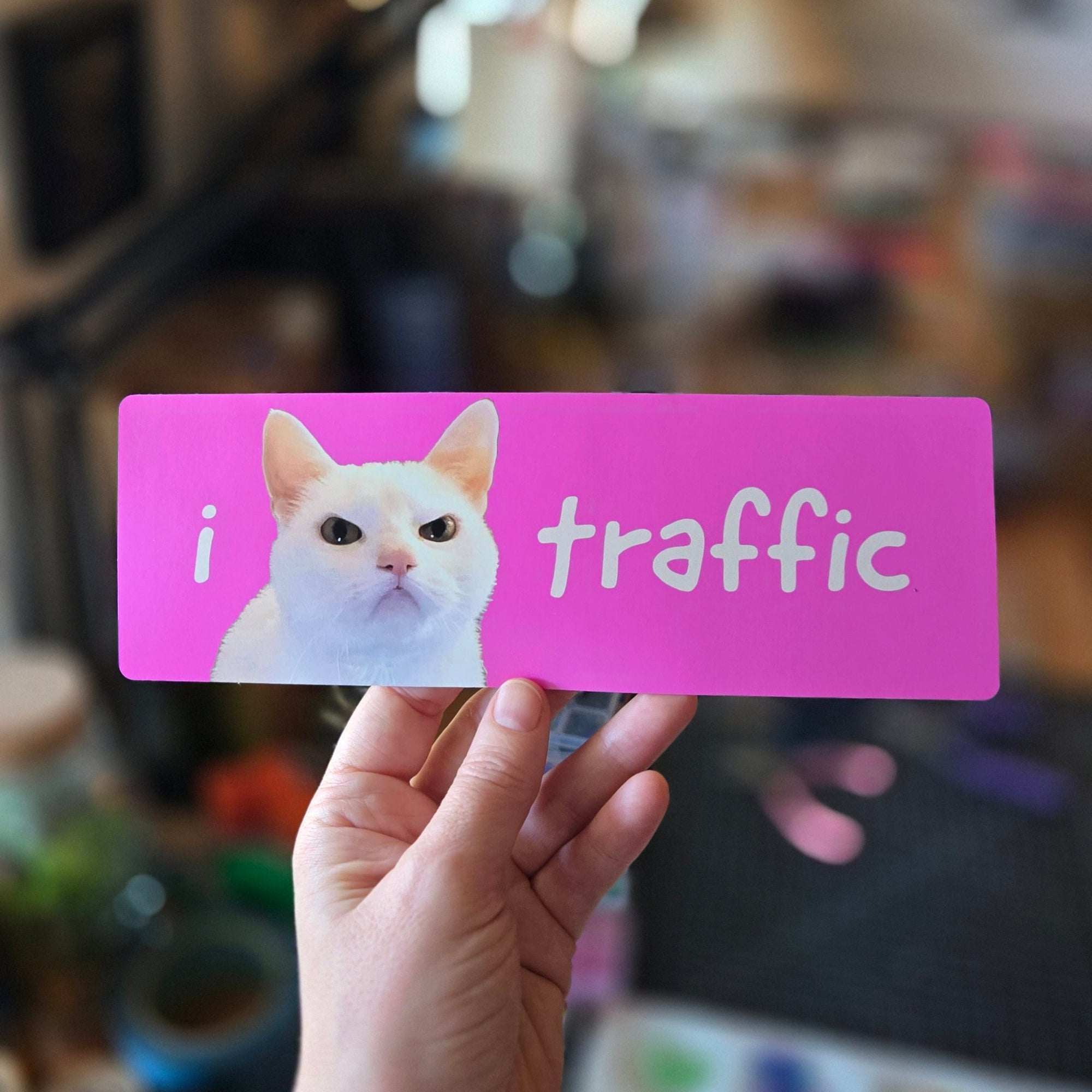 pink rectangular sticker featuring a cat with 'i 😾 traffic' text on a white background