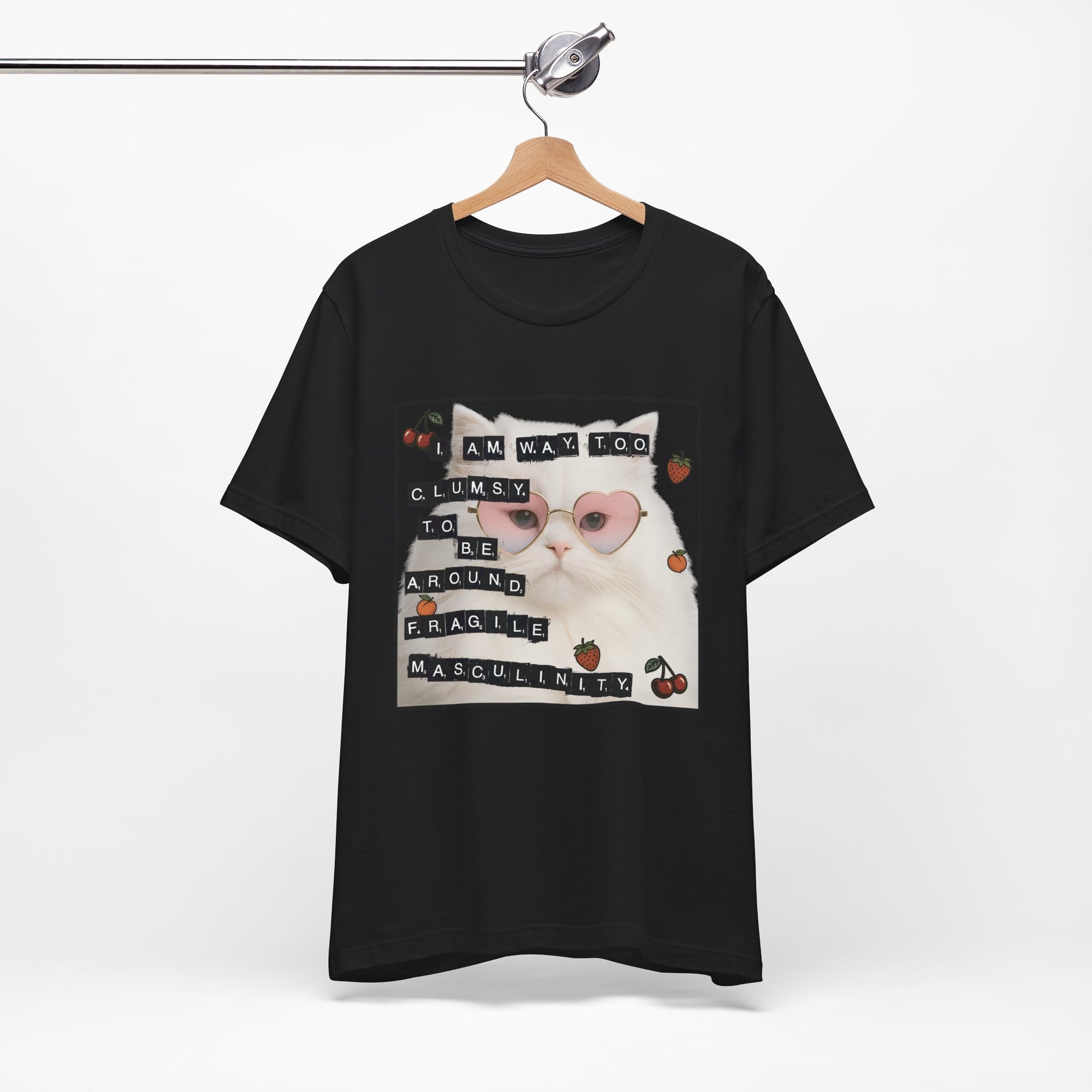 Black t-shirt featuring a fluffy white cat in pink heart-shaped sunglasses with ransom-note style text that says “I am way too clumsy to be around fragile masculinity.”