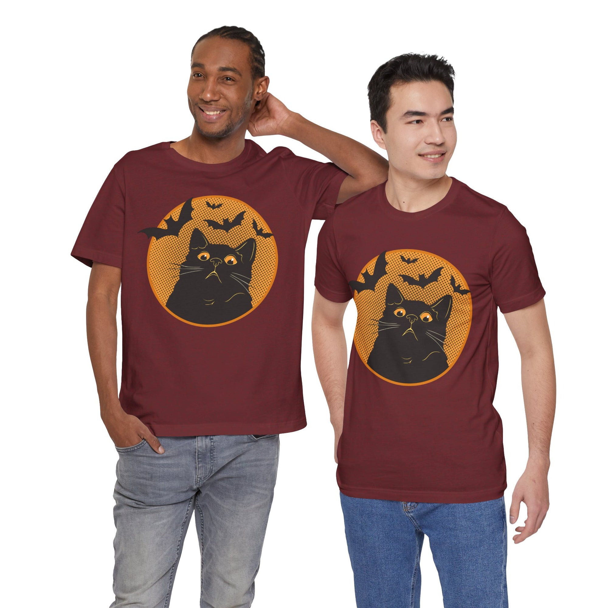 Two men wearing maroon t-shirts with a black cat and bats design on a white background.