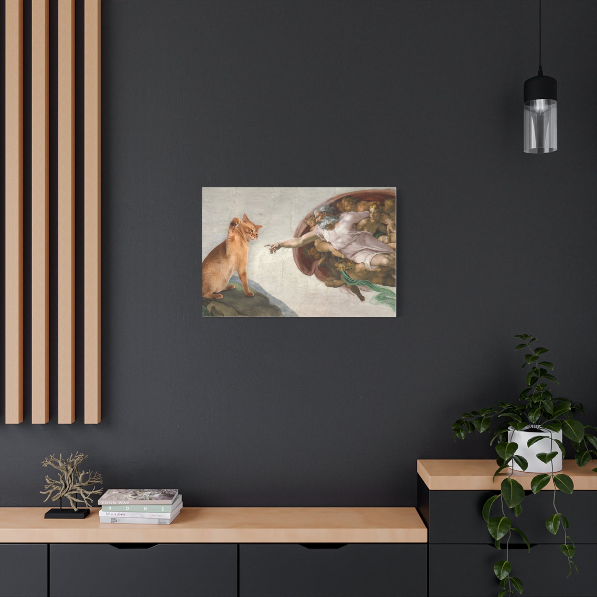 Framed artwork on a dark wall with a wooden shelf and plant below.