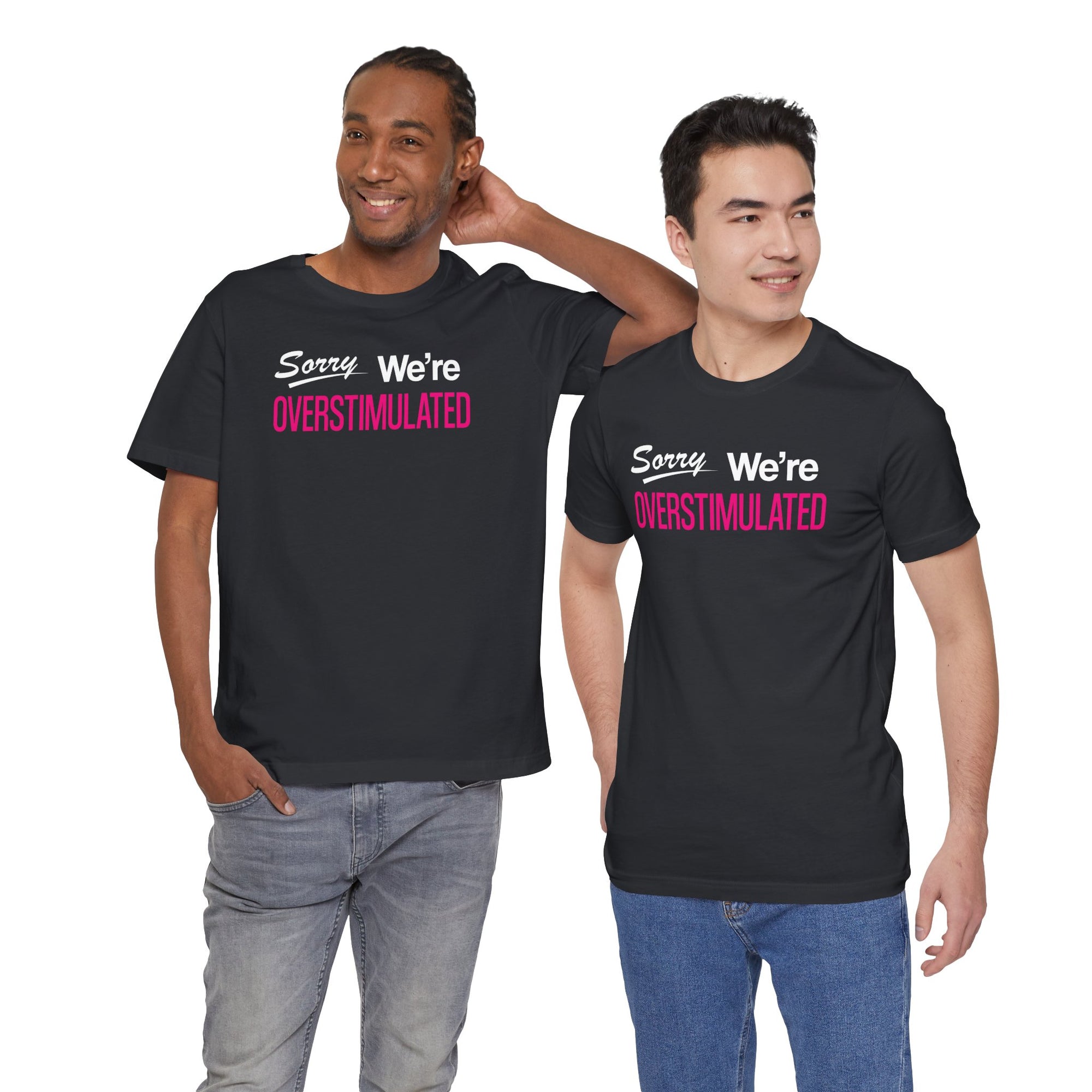 Two people wearing black t-shirt featuring the phrase “Sorry We’re Overstimulated” in white and hot pink text.
