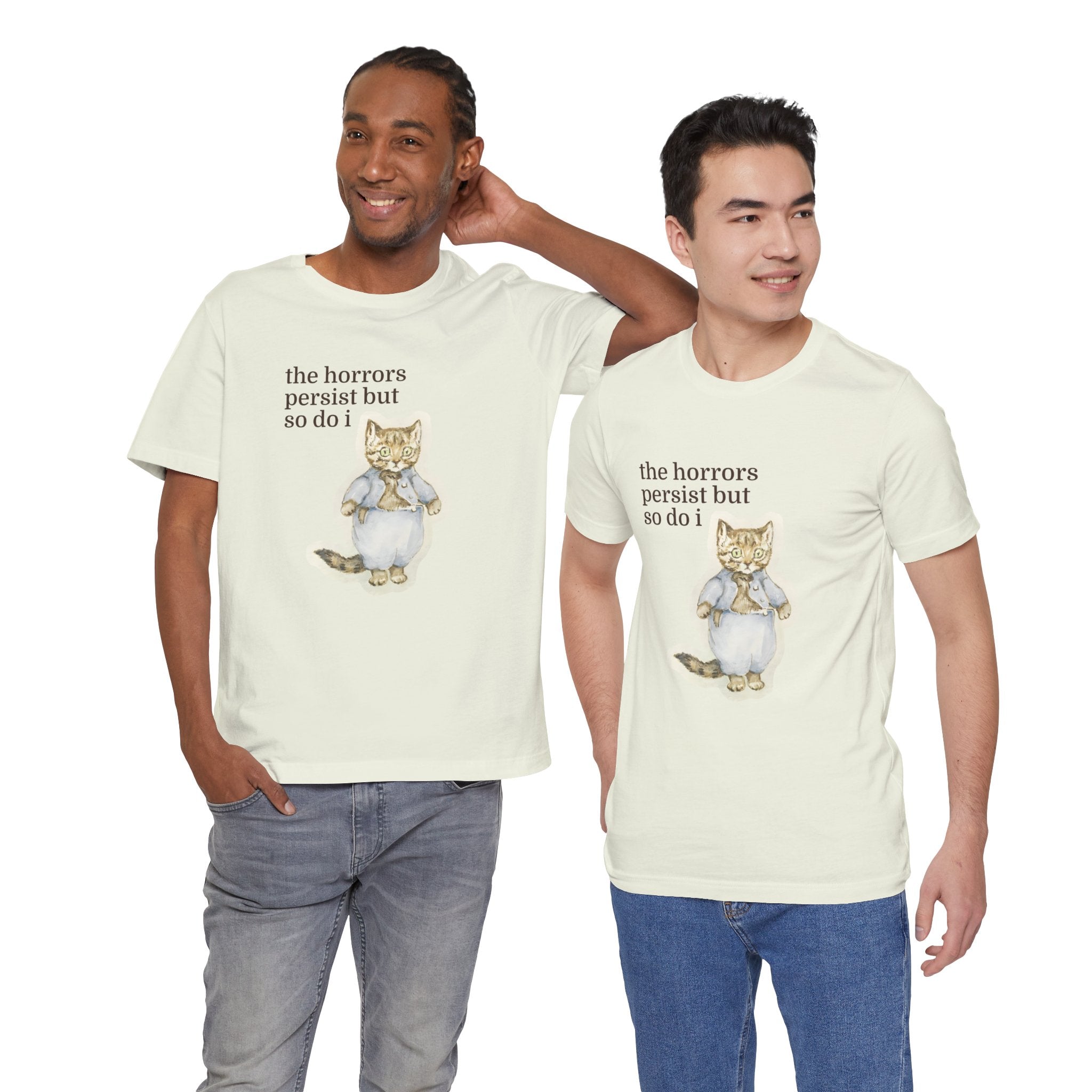 Two men wearing matching t-shirt featuring a vintage-style illustrated cat in blue clothing with the phrase “the horrors persist but so do i.”