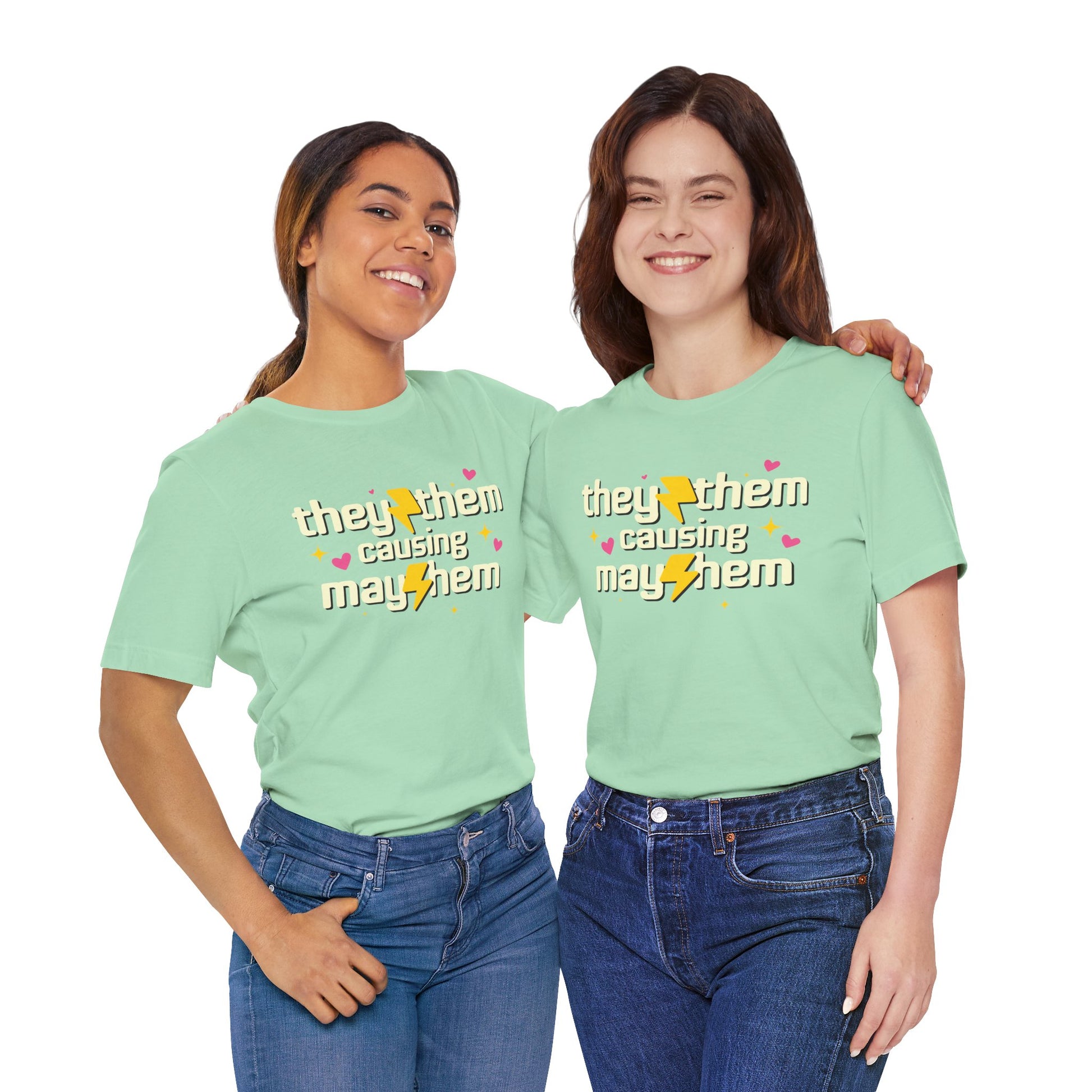 Two people wearing light green t-shirts with 'they them causing mayhem' text.
