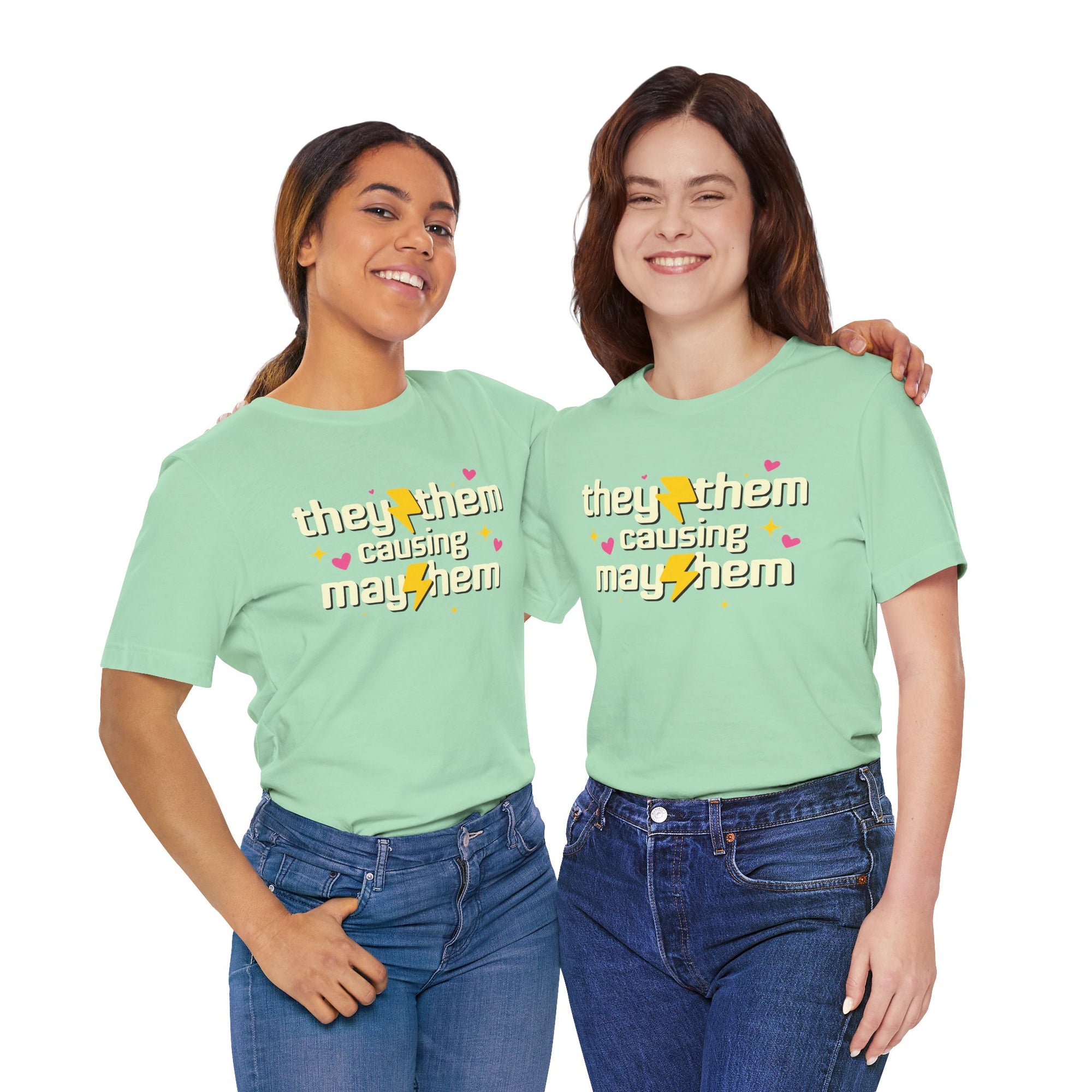 Two people wearing light green t-shirts with 'they them causing mayhem' text.