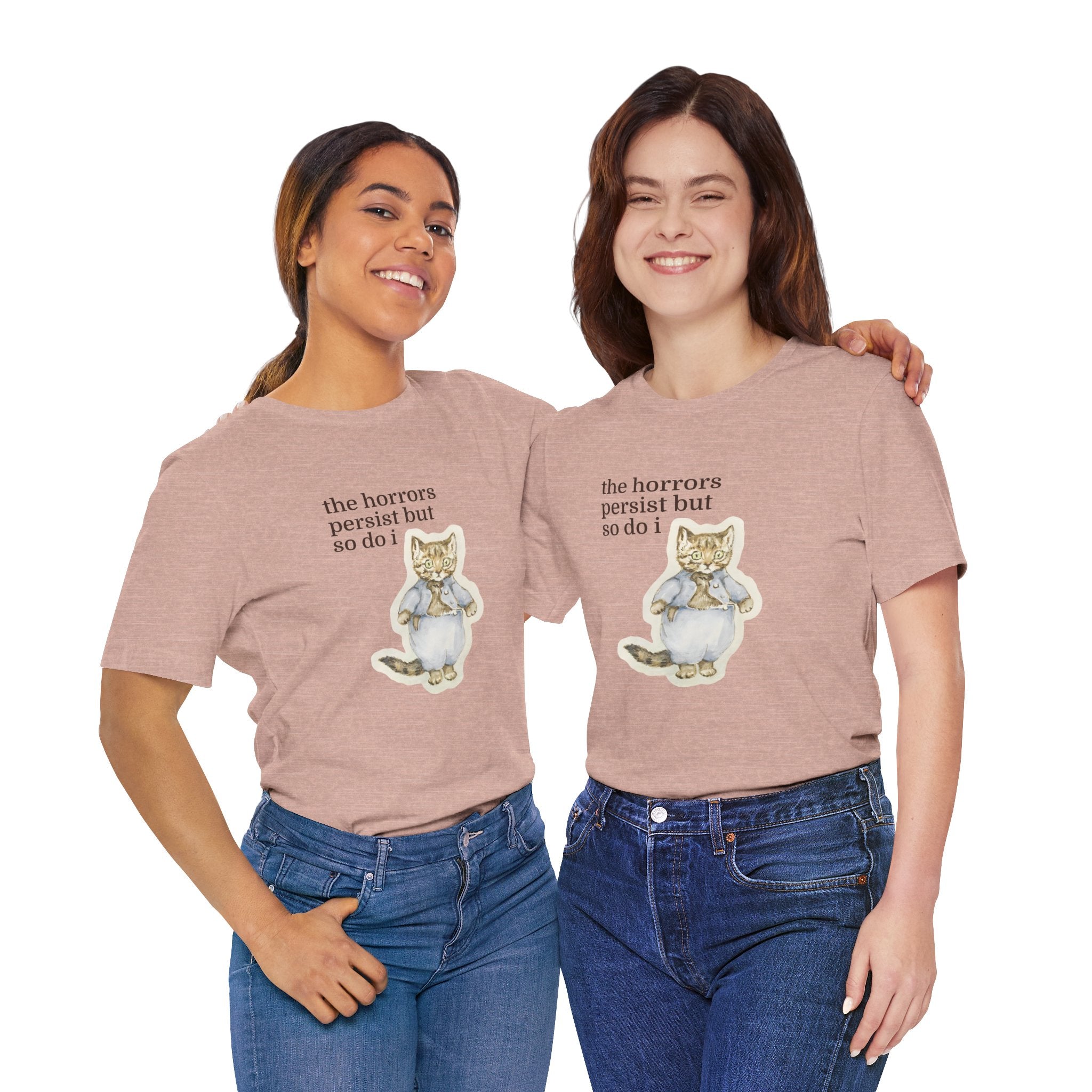Two people wearing matching t-shirt featuring a vintage-style illustrated cat in blue clothing with the phrase “the horrors persist but so do i.”