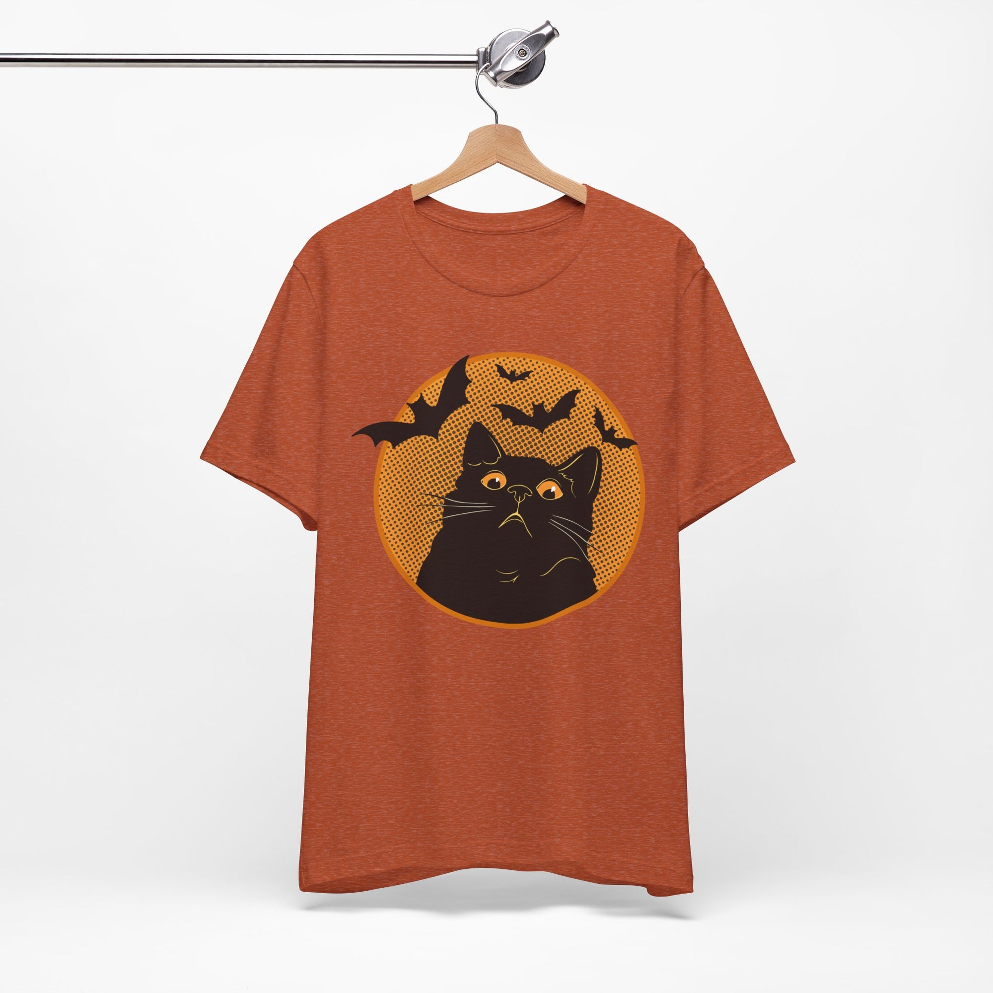 Orange t-shirt featuring a retro-style black cat graphic with orange moon, flying bats, and Halloween-inspired details.