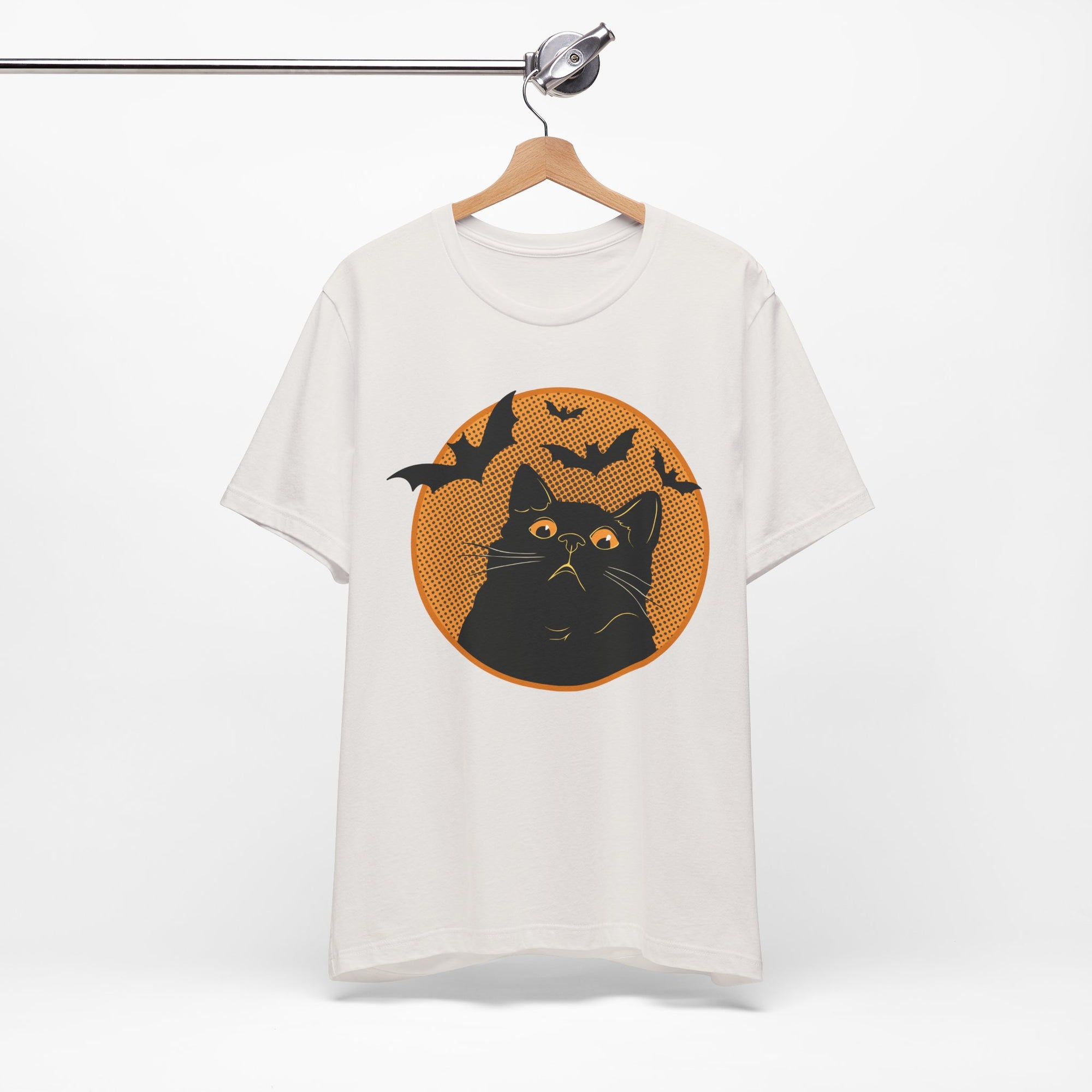 White t-shirt featuring a retro-style black cat graphic with orange moon, flying bats, and Halloween-inspired details.