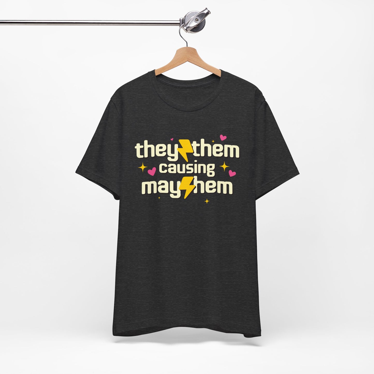 Black t-shirt with 'they/them causing mayhem' text on a hanger against a white background